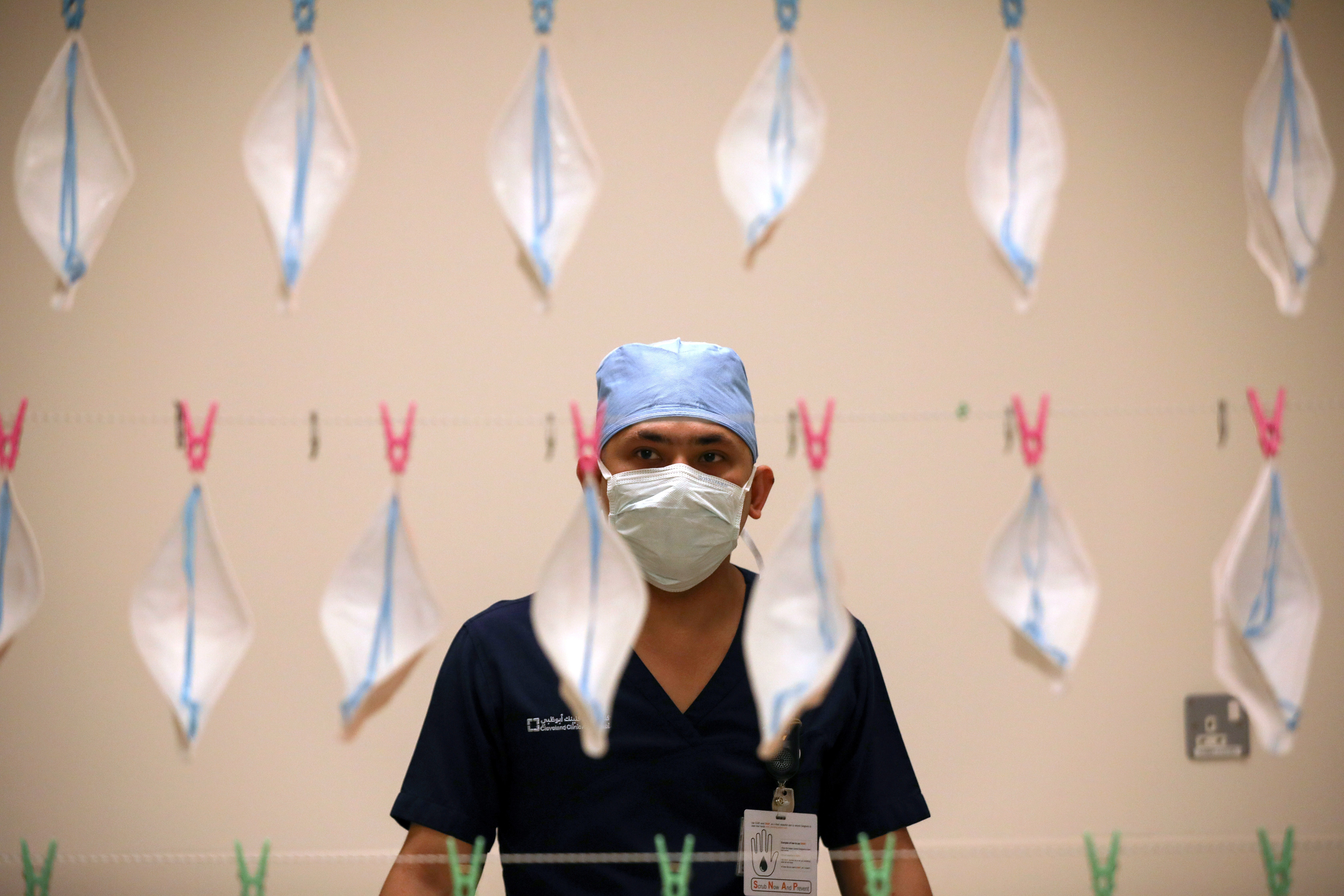 A technician hangs up face masks to be sterilised with UVC light. Photo: Reuters
