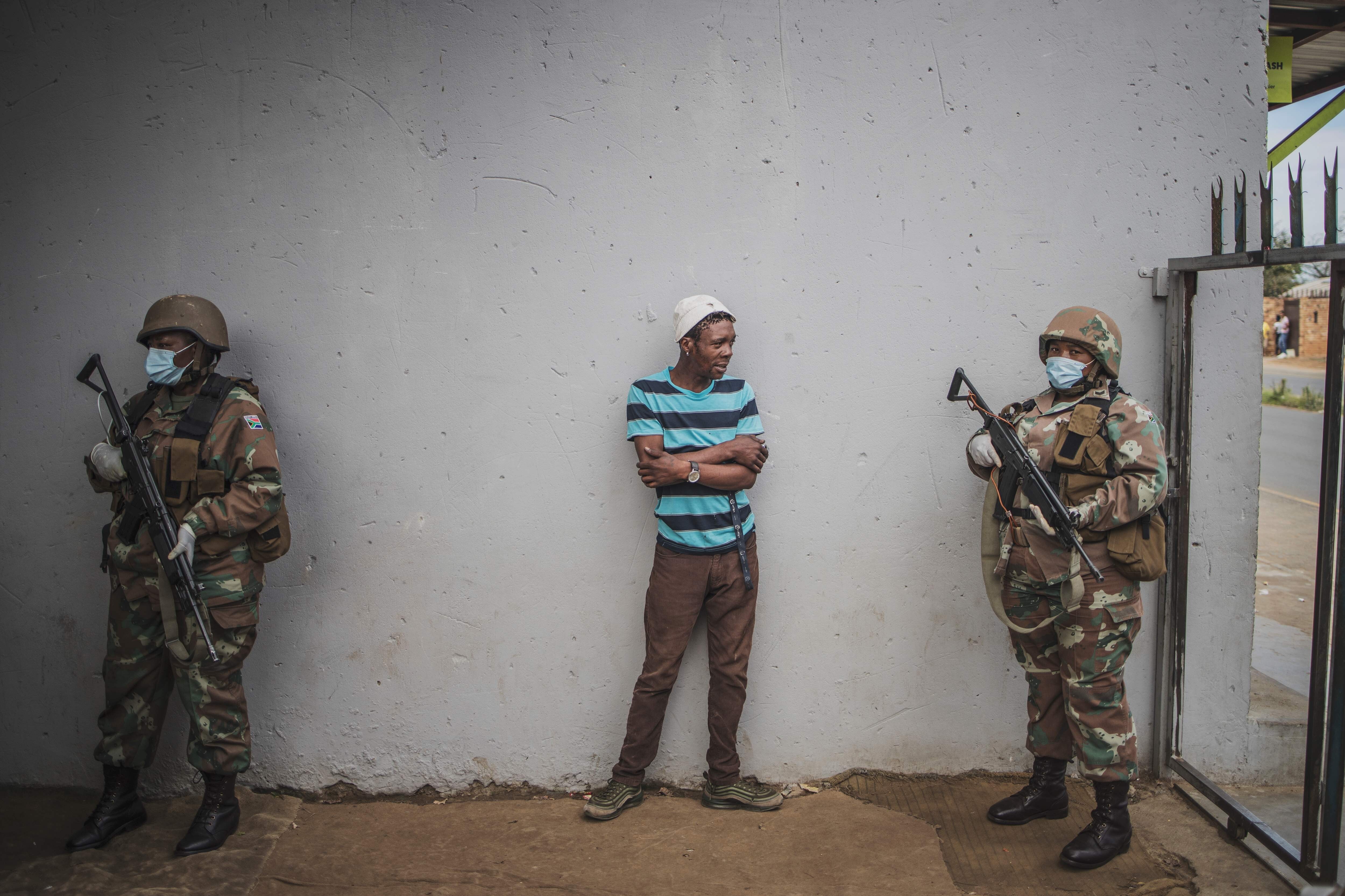 A man is questioned by a South African National Defence Force patrol after his corner shop was found open in Eldorado Park on March 30. South Africa came under a nationwide lockdown on March 27, joining other African countries imposing strict curfews and shutdowns in an attempt to halt the spread of Covid-19. Photo: AFP
