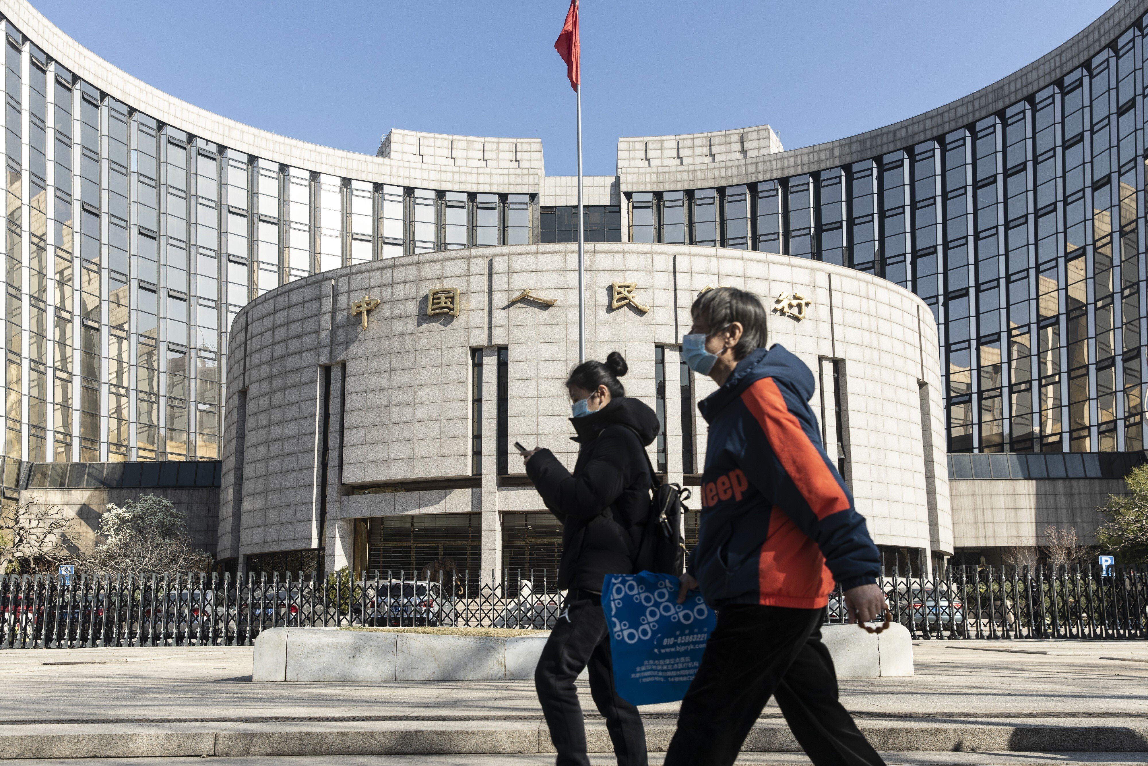 Pedestrians walk past the People's Bank of China headquarters in Beijing on March 17. Photo: Bloomberg