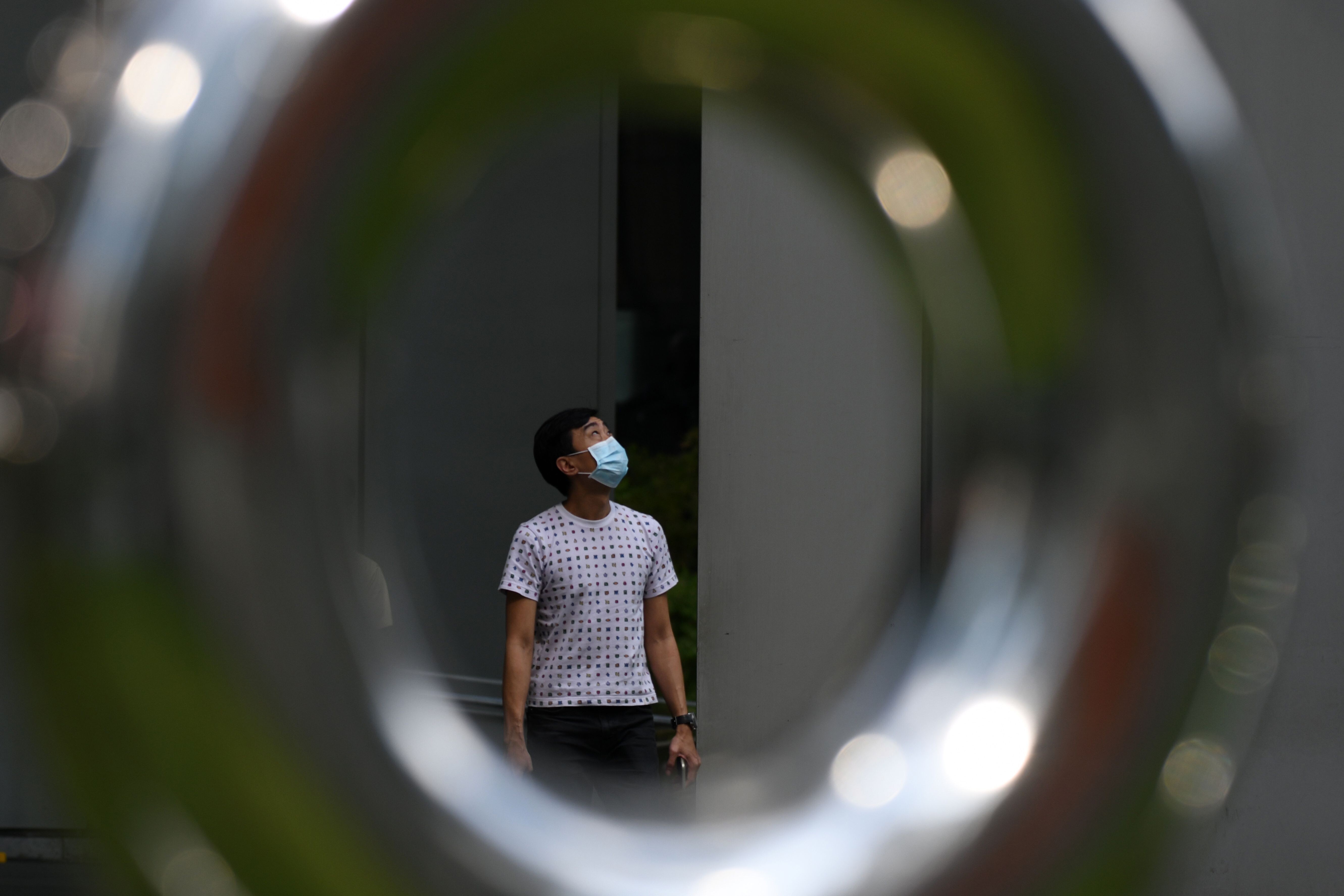 A man wearing a face mask as a preventive measure against the spread of the Covid-19 coronavirus walks in Singapore’s Raffles Place financial business district. Photo: AFP