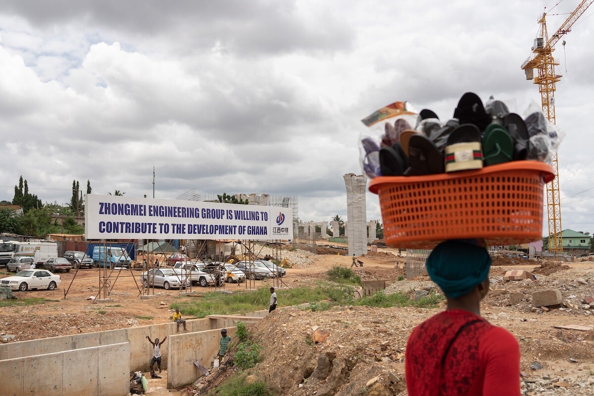 A woman walks past a Chinese construction site for a new flyover in the outskirts of Accra. Ghana has turned to investment from Chinese companies to improve the nation’s infrastructure. Photo: Ruom