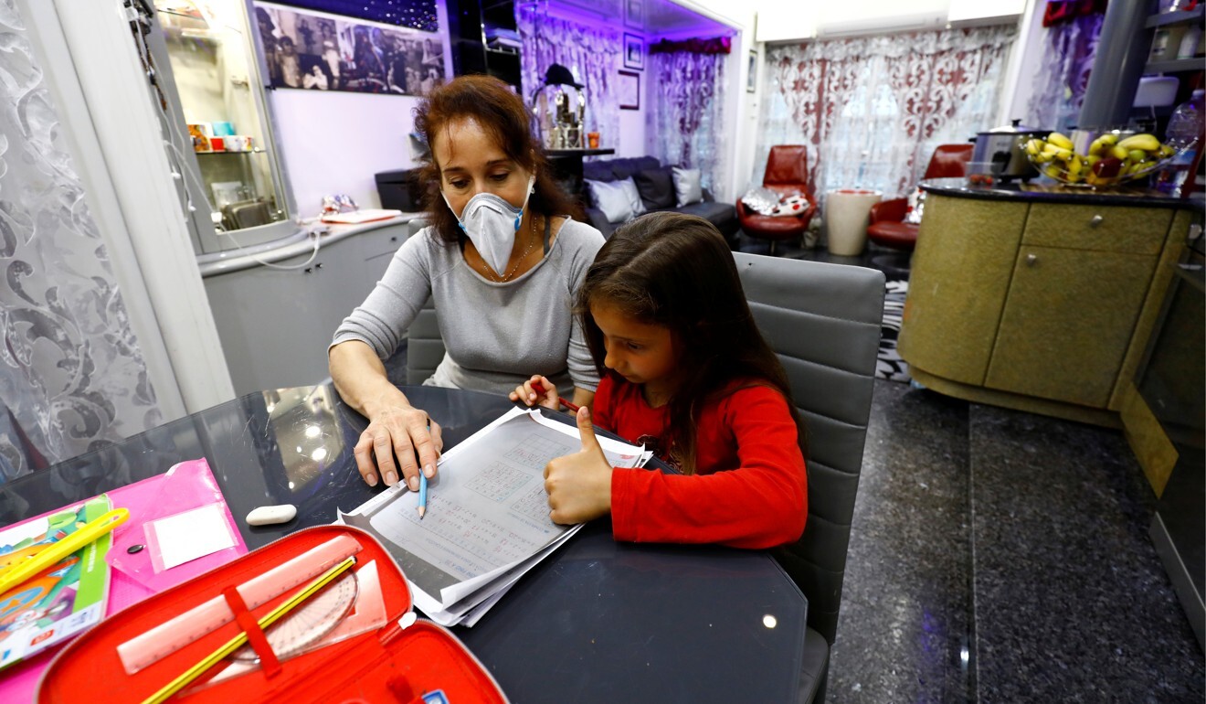 A girl does school work with her mother in Santa Teresa di Riva, Italy, on April 24, amid the coronavirus outbreak. Photo: Reuters