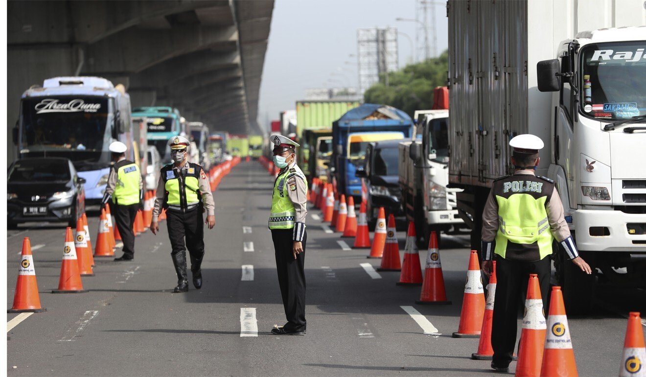 Indonesian police stand at a checkpoint after the imposition of travel restriction to curb the spread of the new coronavirus. Photo: AP