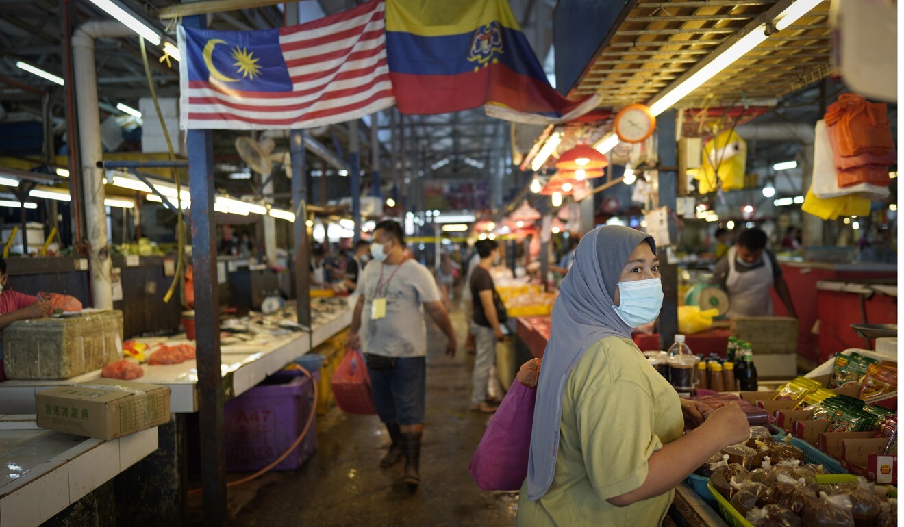 A Malaysian woman wearing a face mask shops for food at a wet market in downtown Kuala Lumpur. Popular Ramadan bazaars where food, drinks and clothing are sold, have been banned. Photo: AP