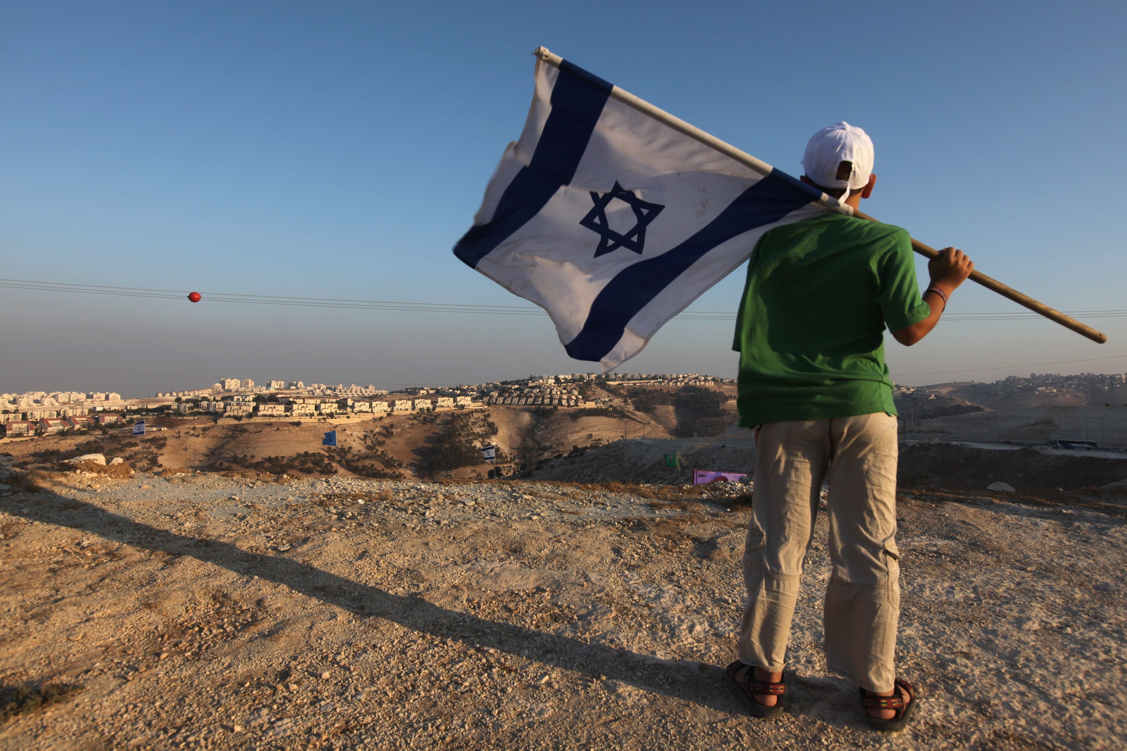 A right-wing supporter holds his national flag near the Jewish settlement of Maale Adumim, east of Jerusalem. File photo: AFP