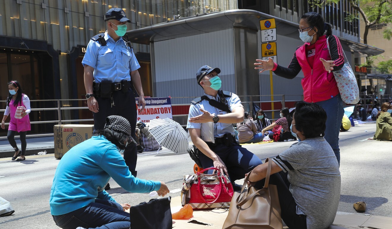Police officers ask foreign domestic helpers gathered in Central, Hong Kong, to disperse as a measure against the coronavirus. Photo: Edmond So