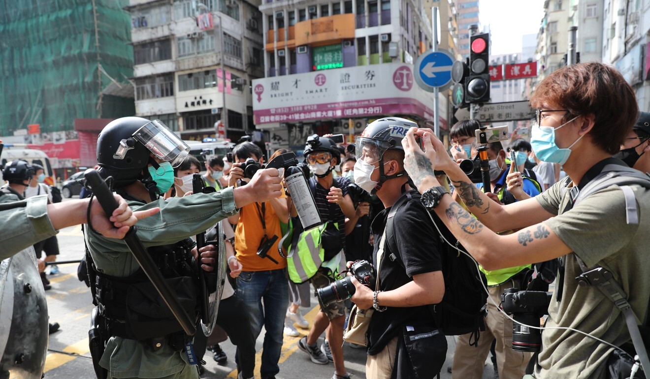 A police officer points pepper spray at journalists in Mong Kok. Photo: Sam Tsang