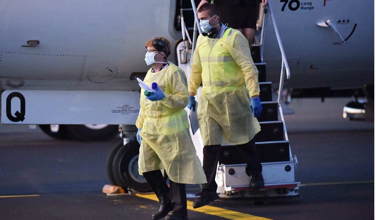 Australia biosecurity officials alight from a plane carrying the New Zealand Warriors rugby league team as they arrive in Tamworth on May 3. Photo: AFP