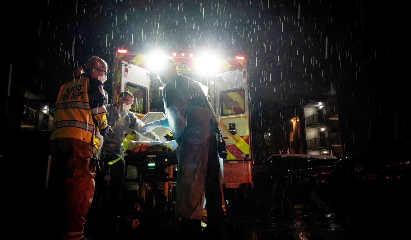 Firefighters and paramedics wearing personal protective equipment prepare to transport a suspected coronavirus patient in Maryland, US. Photo: AFP