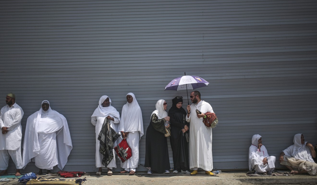 Muslim pilgrims shelter themselves from the heat as they attend Friday afternoon prayers outside the Grand Mosque in the holy city of Mecca, Saudi Arabia. Photo: AP