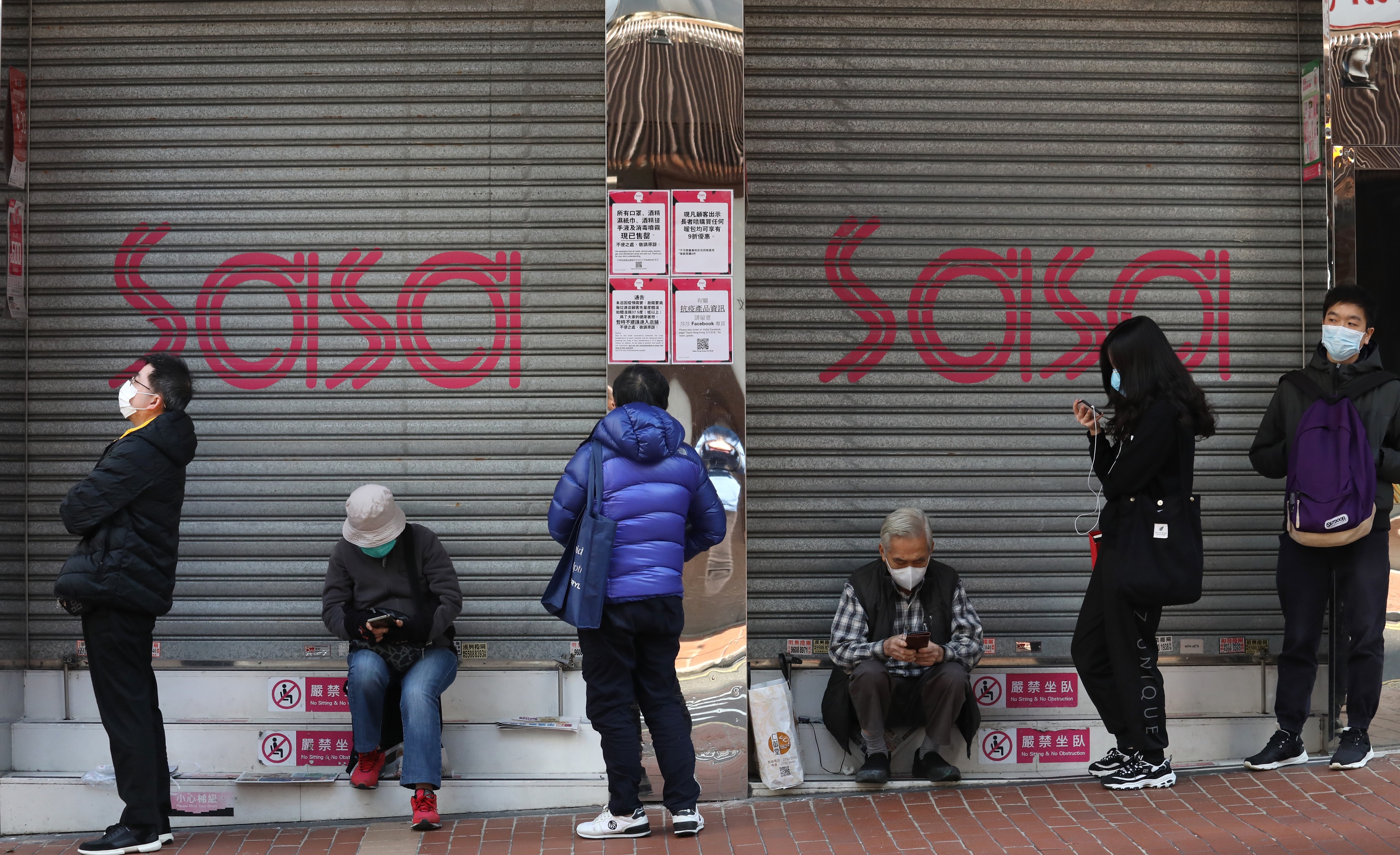 The queue of people, waiting in line for the opening of a pharmacy to buy surgical masks outside a shuttered Sasa outlet at Jardine's Bazaar in Hong Kong. Photo: Nora Tam