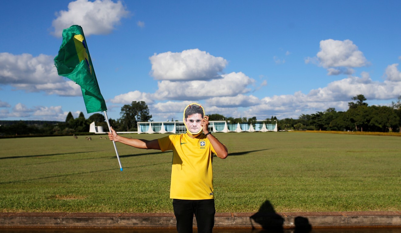 A supporter of Jair Bolsonaro wears a mask that reads ‘traitor’ with the image of Sergio Moro in front of the Alvorada Palace in Brazil. Photo: Reuters
