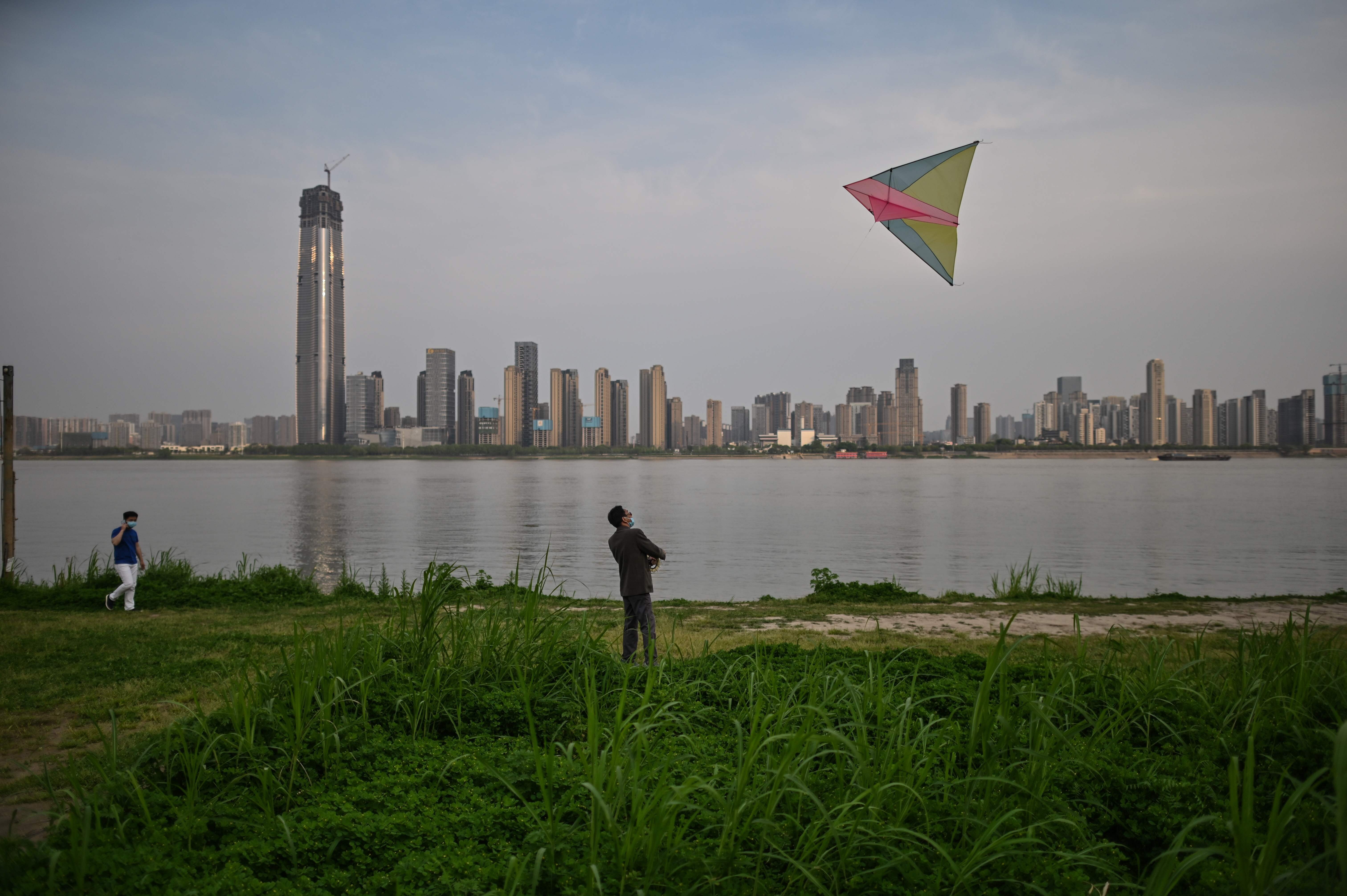 A man flies a kite along the Yangtze River in Wuhan on April 8, after the Chinese authorities lifted a more than two-month prohibition on outbound travel. Photo: AFP