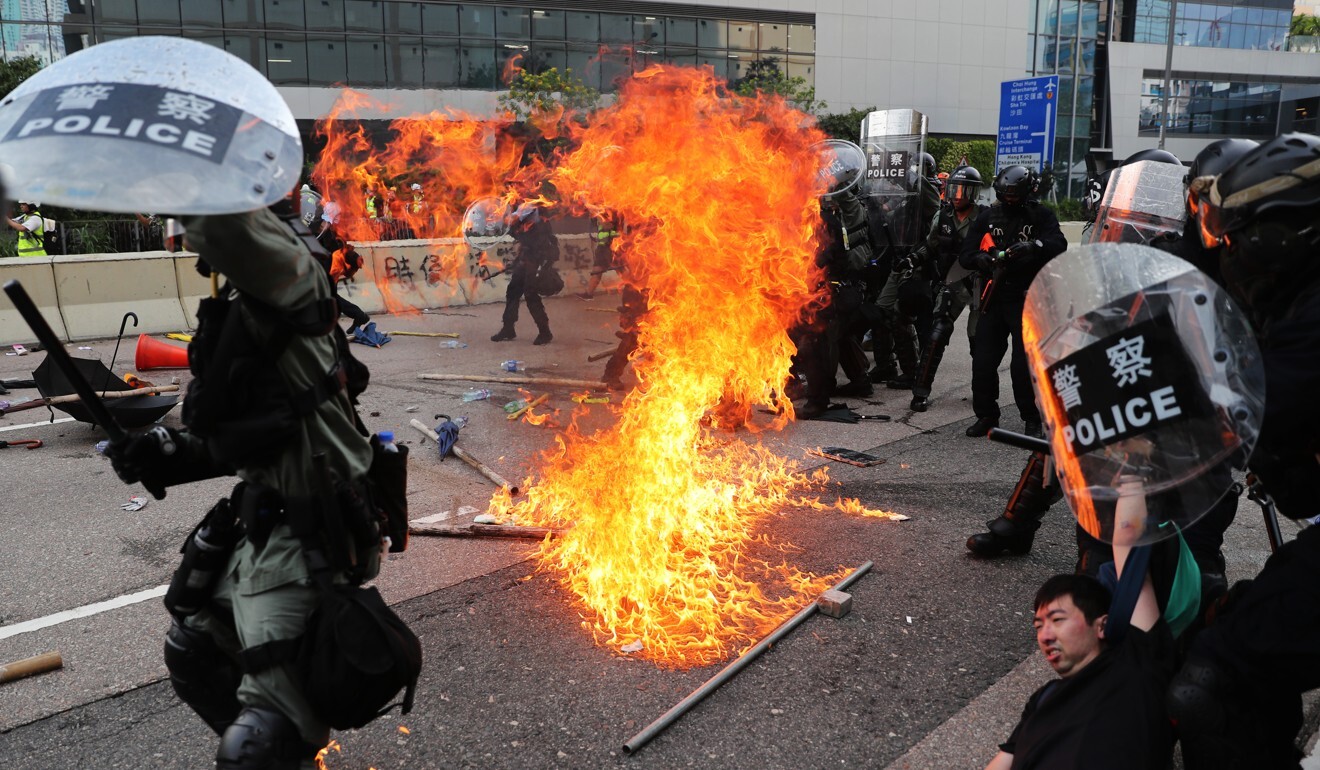 A petrol bomb explodes near riot police as they arrest protesters near the Ngau Tau Kok police station, Ngau Tau Kok on August 24. The photo earned Sam Tsang a merit award in the spot news category. Photo: Sam Tsang