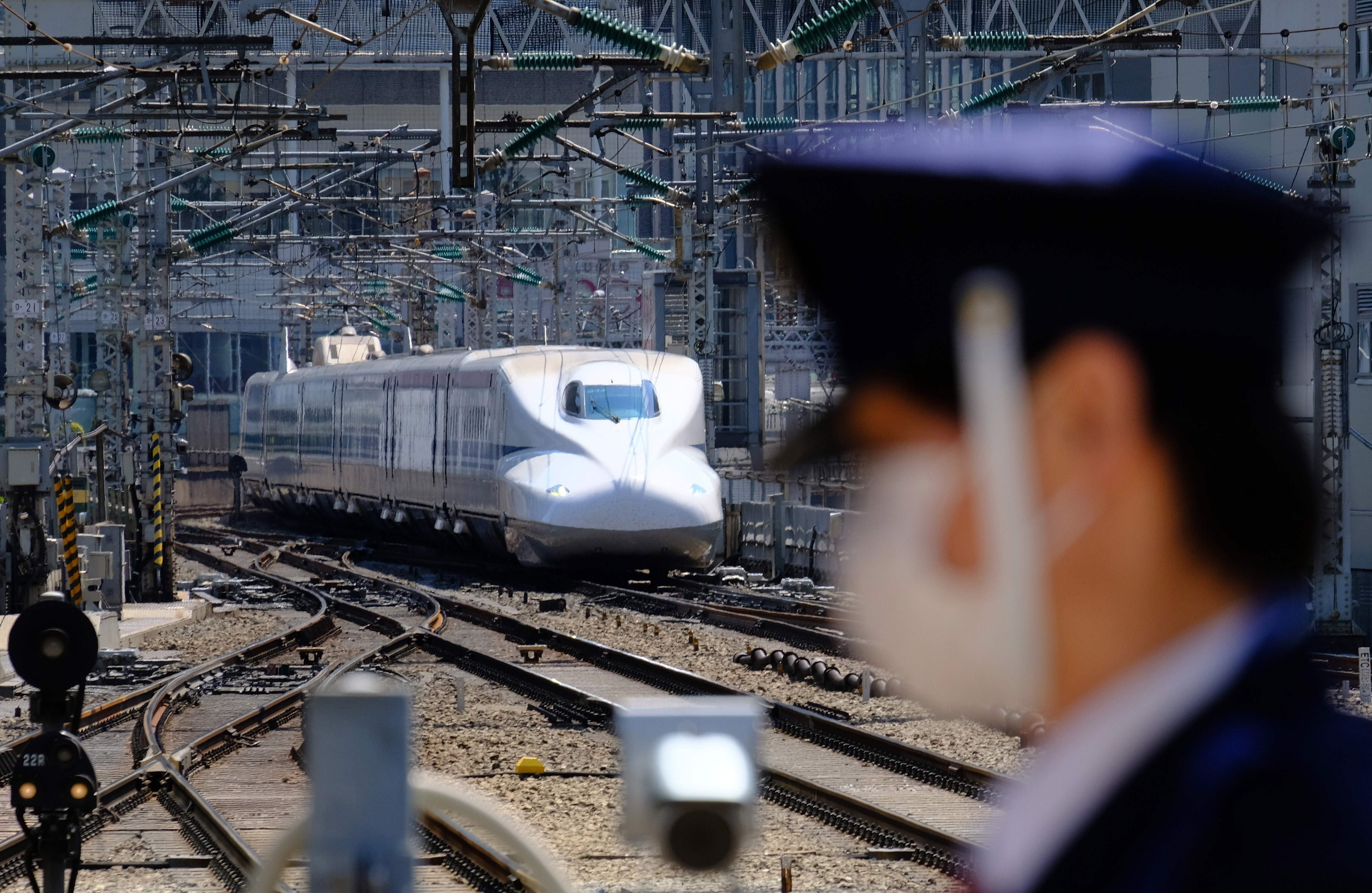 A security guard wearing a face mask stands in front of a Shinkansen bullet train upon its arrival at Tokyo Station on April 25. Photo: AFP