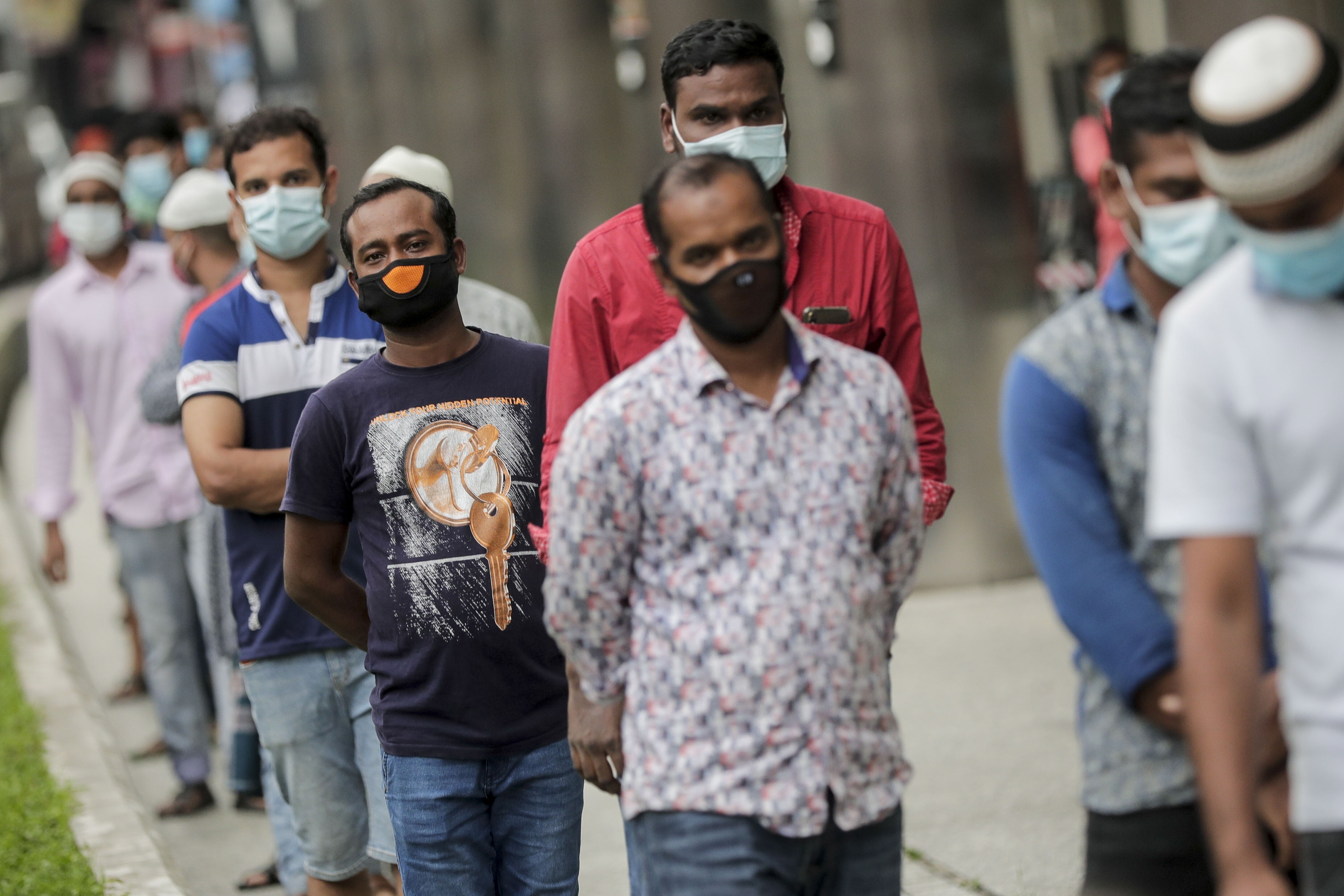 Migrant workers wear masks while queuing at a meal distribution point in the Little India district of Singapore on May 6. Photo: EPA-EFE