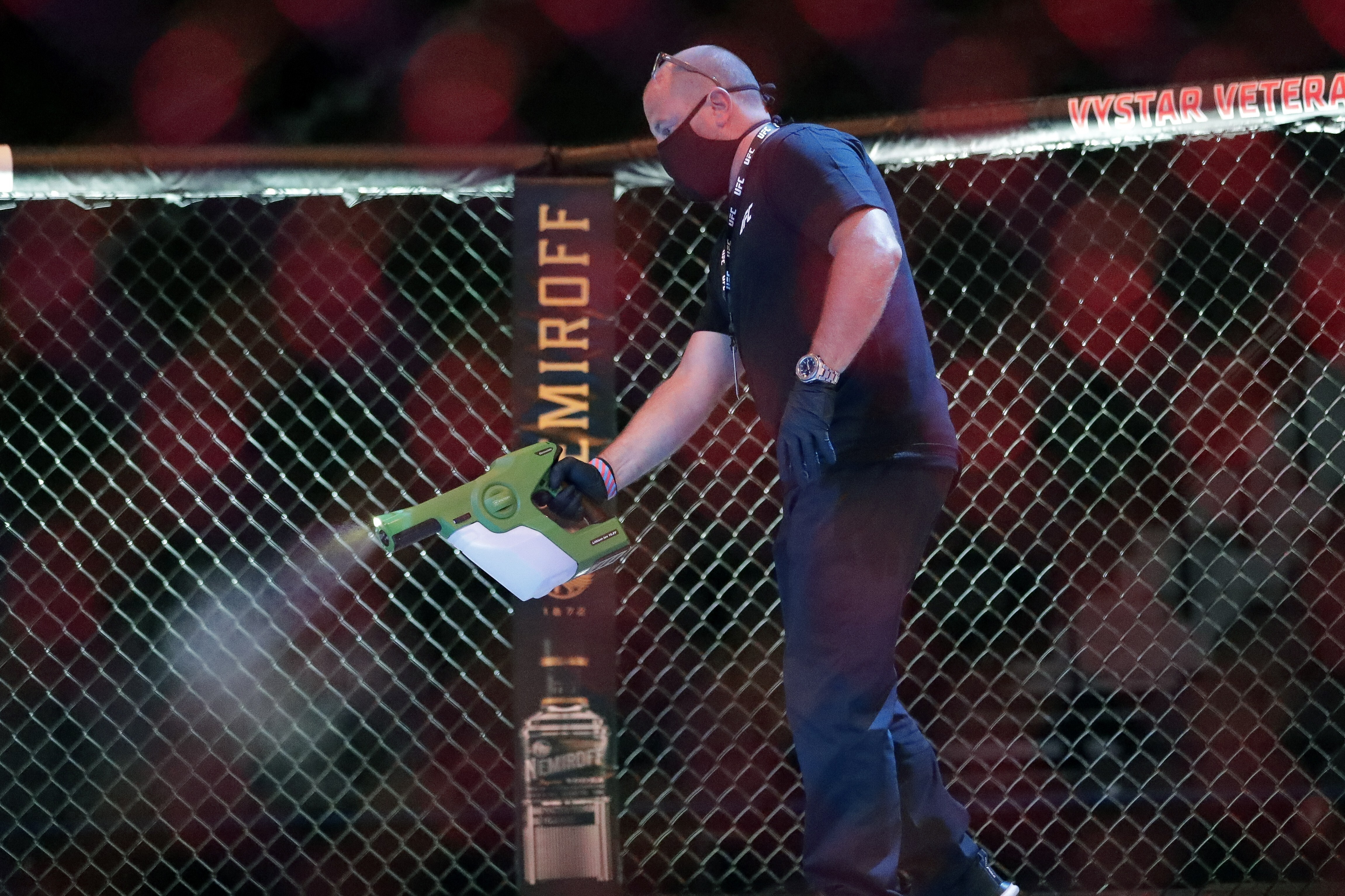 A worker sprays sanitiser in the octagon before UFC 249. Photo: AP