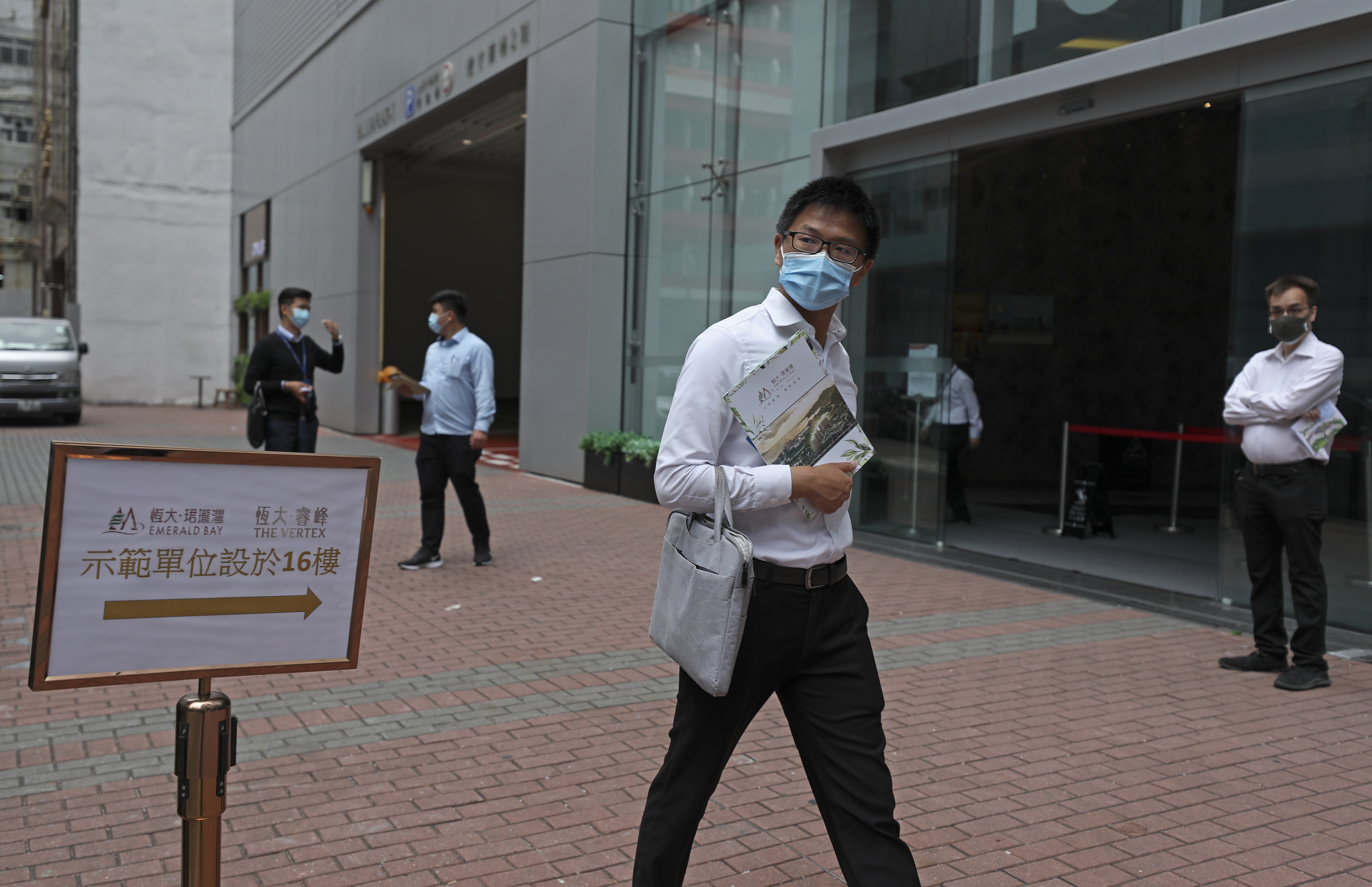 A real property agent approaches pedestrians near Billion Plaza, hoping to sell Emerald Bay flat units in Tuen Mun, Hong Kong on May 9. Photo: Xiaomei Chen