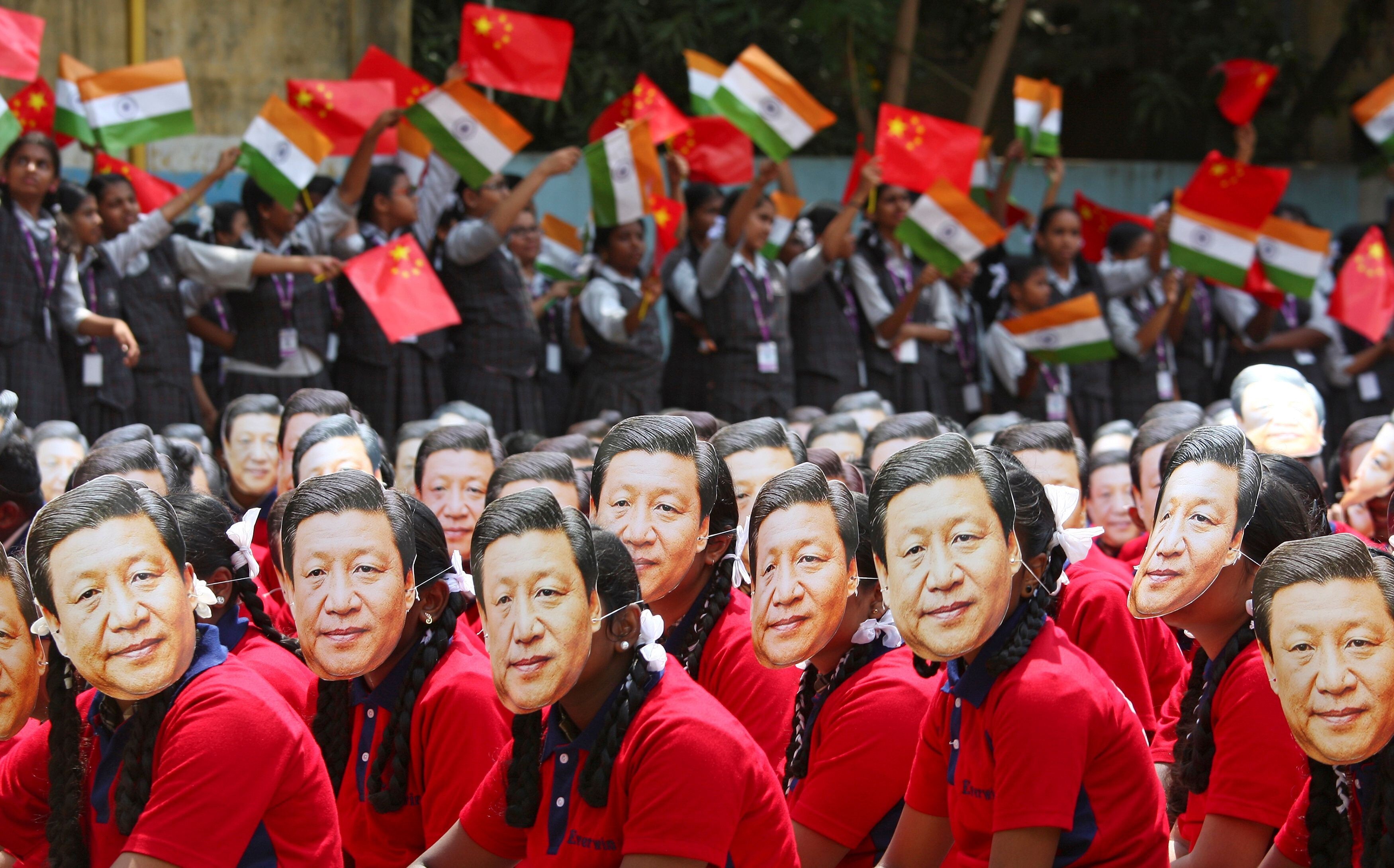 Students in Chennai, India, wear masks of China’s President Xi Jinping as others wave the national flags of India and China, ahead of his informal summit with Indian Prime Minister Narendra Modi, on October 10 last year. Photo: Reuters