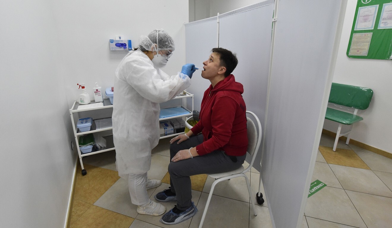 A health worker takes a sample from a man at a drive-in Covid-19 testing facility in Moscow. Photo: AFP