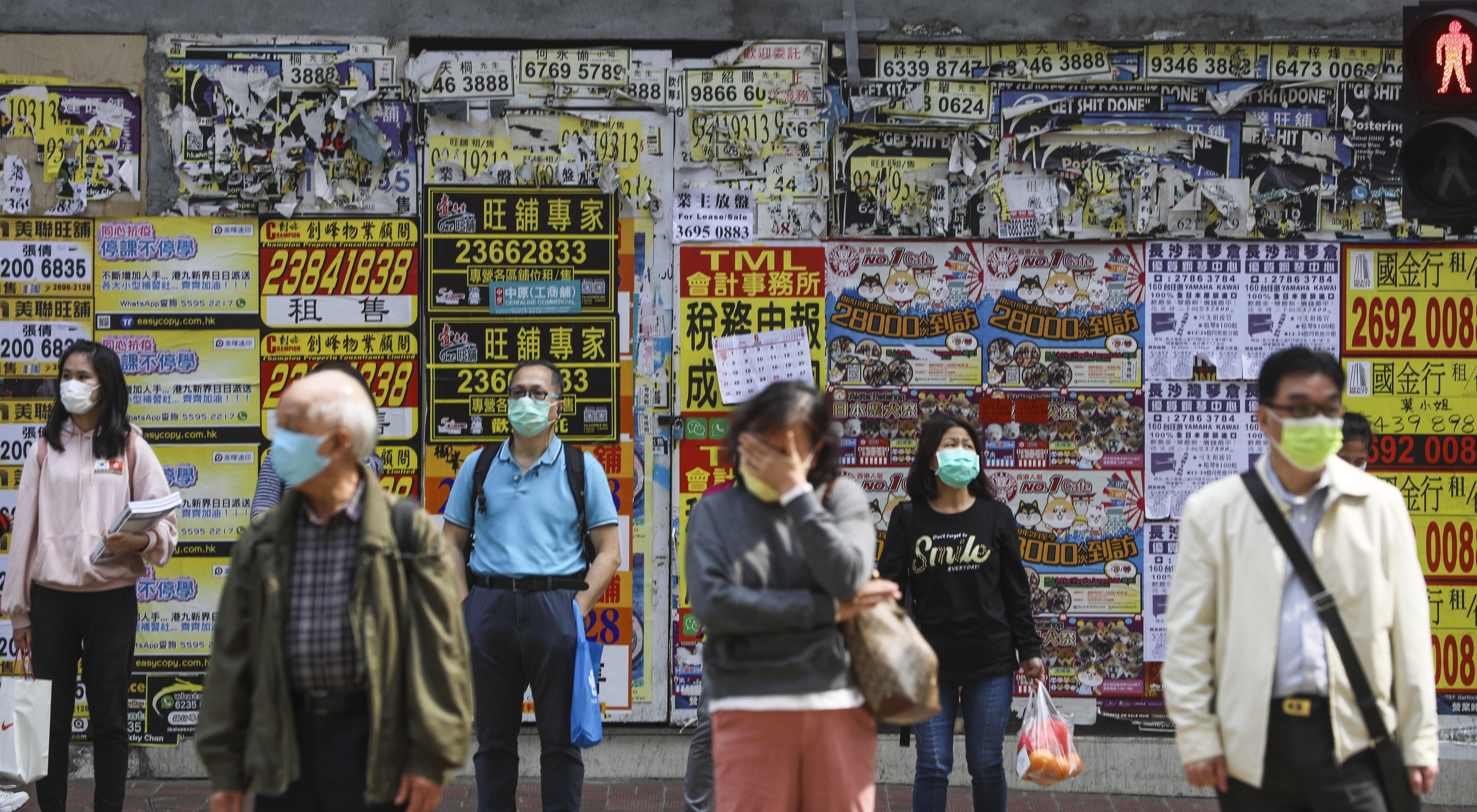People wearing masks wait in front of a shuttered retail space in Causeway Bay. Photo: Sam Tsang