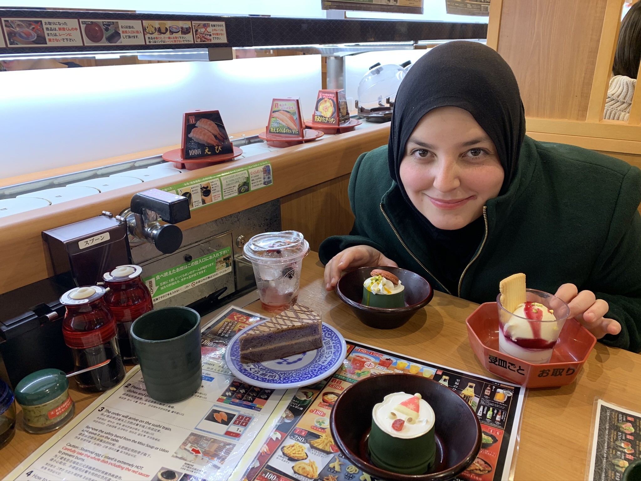 Minkara smiles in a Tokyo conveyor sushi restaurant. Photo: courtesy of Mona Minkara