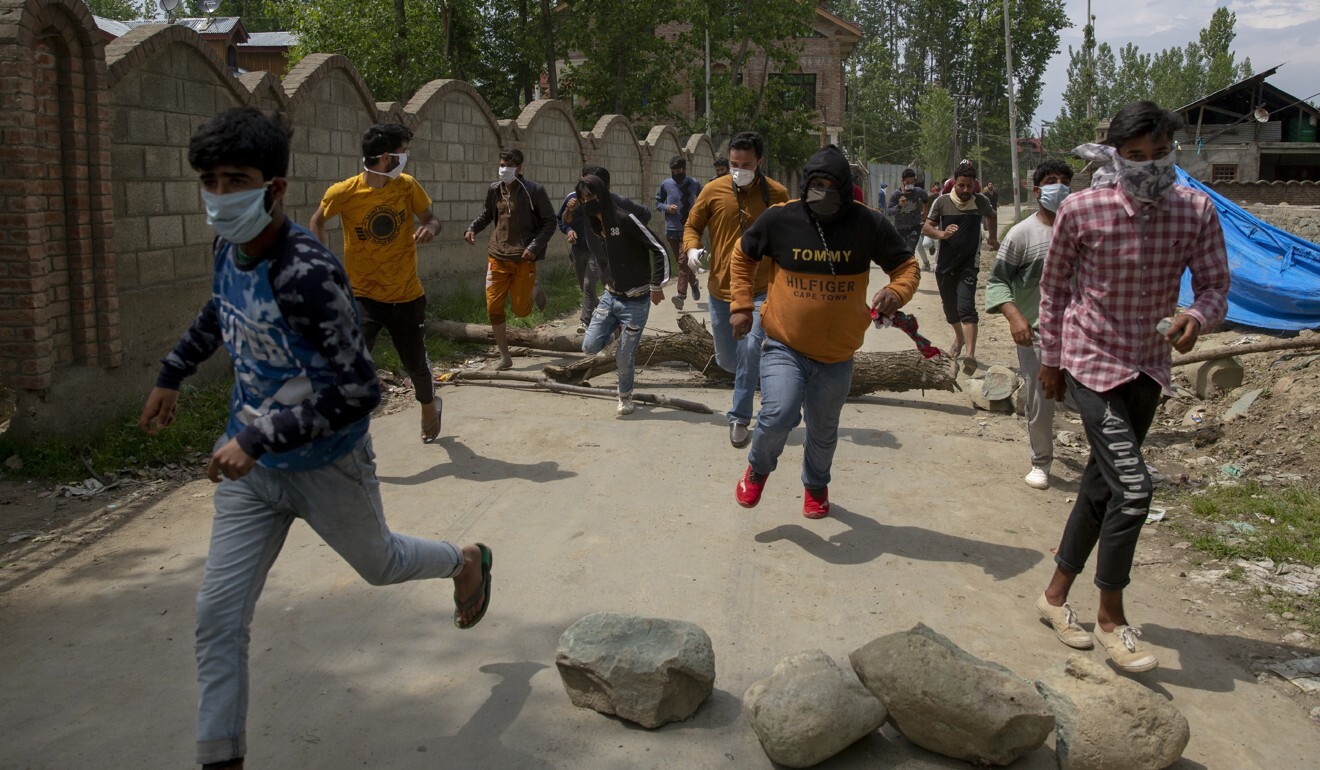 Kashmiri villagers run for cover as policemen chase after firing tear gas during a protest on May 13, 2020. Photo: AP