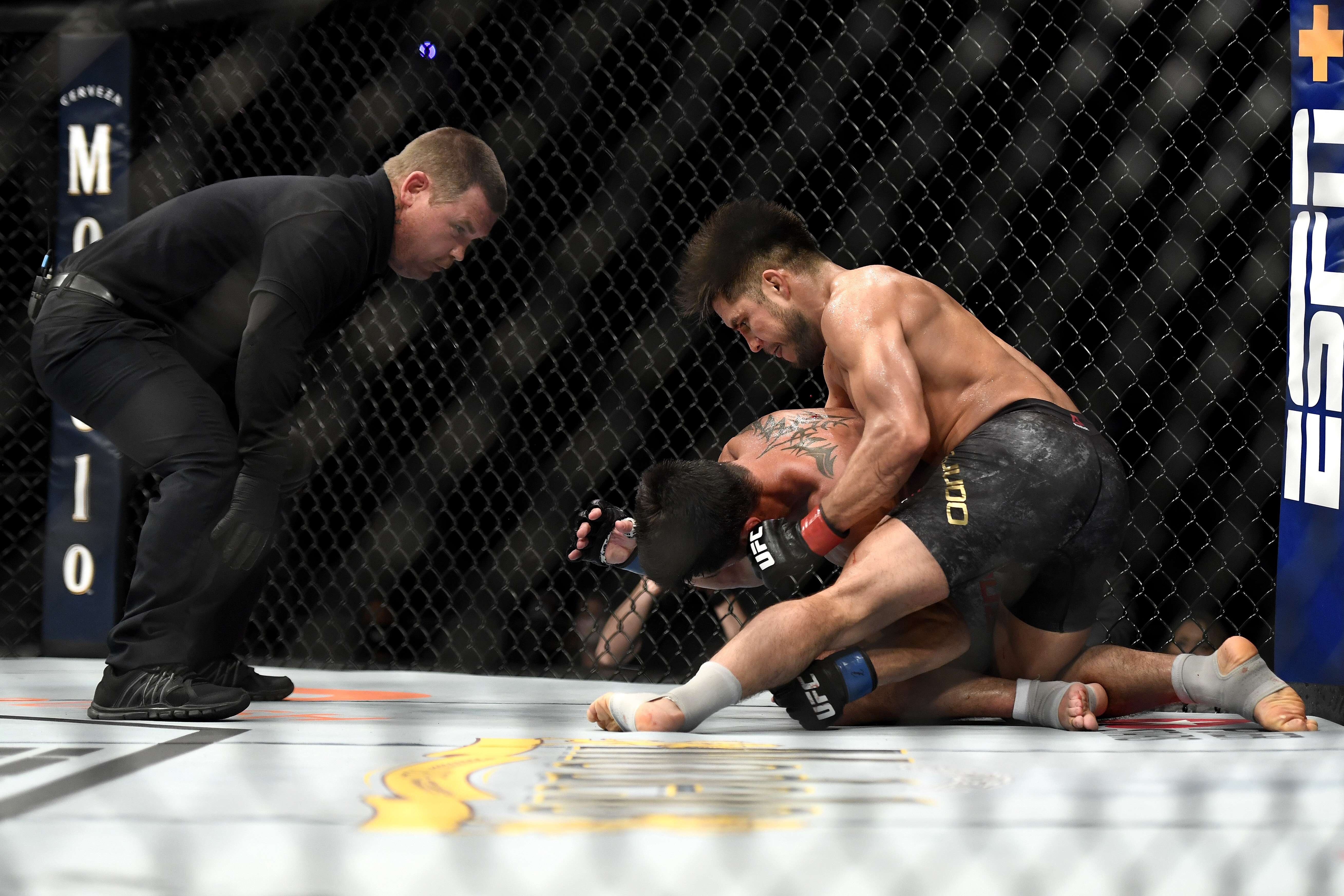 Henry Cejudo punches Dominick Cruz on the ground before referee Keith Peterson steps in at UFC 249. Photo: AFP
