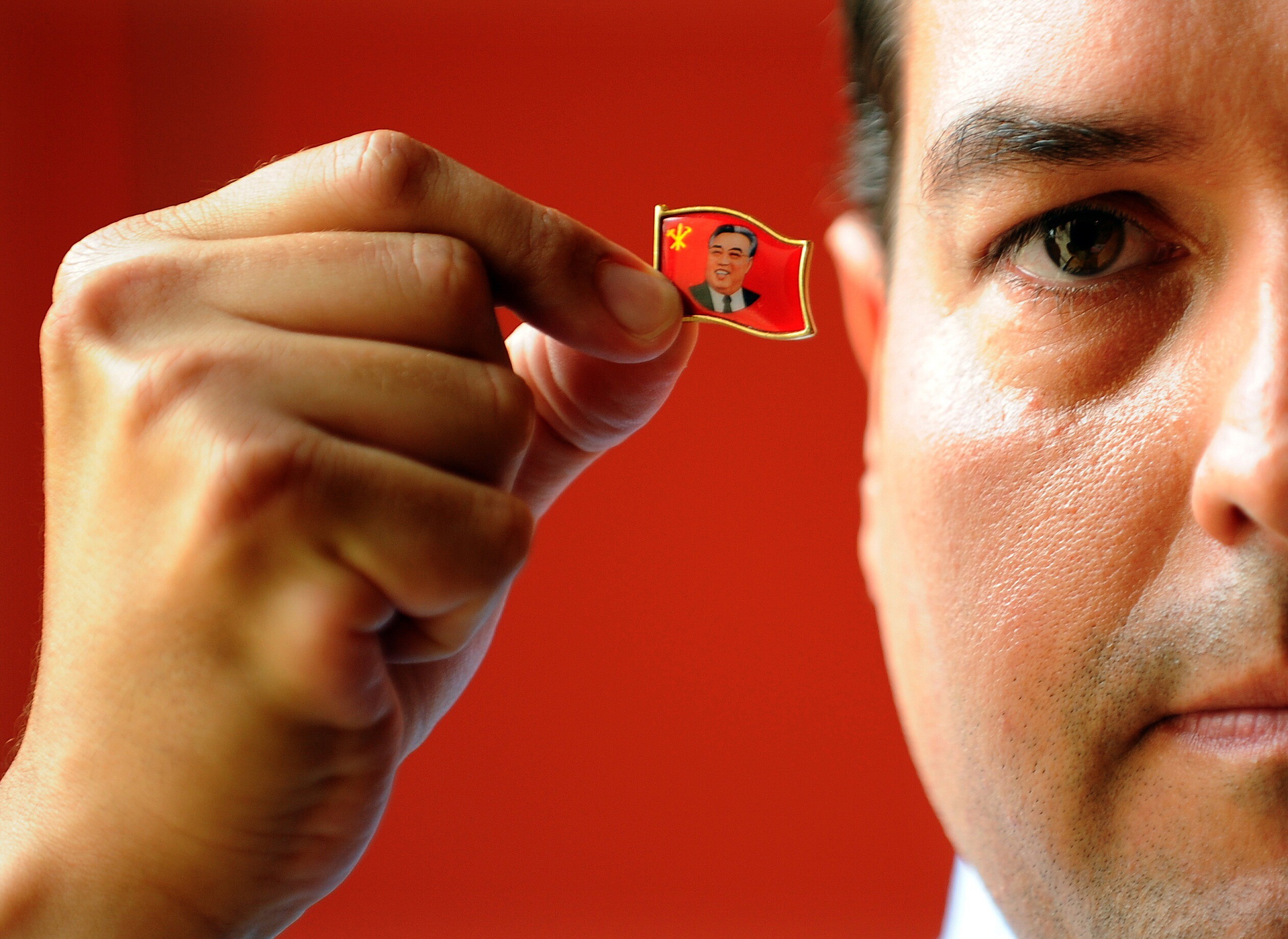 Alejandro Cao de Benós, a special delegate to North Korea’s Committee for Cultural Relations with Foreign Countries, holds a pin of the country’s first supreme leader, Kim Il-sung. Photo: AFP