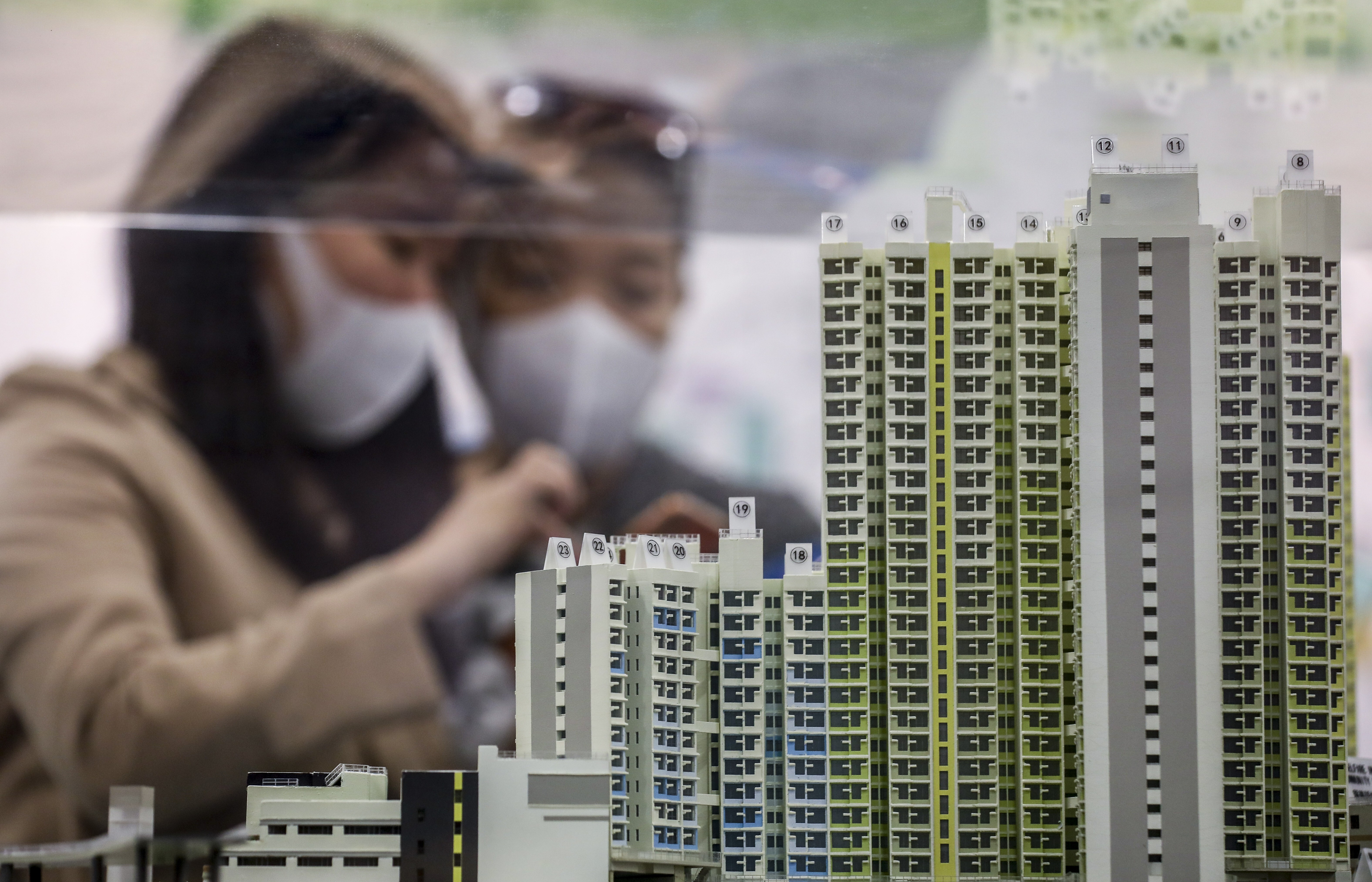 Potential homebuyers wearing protective face masks look at a model of Home Ownership Scheme flats at the Housing Authority customer service centre in Lok Fu on March 2. Photo: Winson Wong