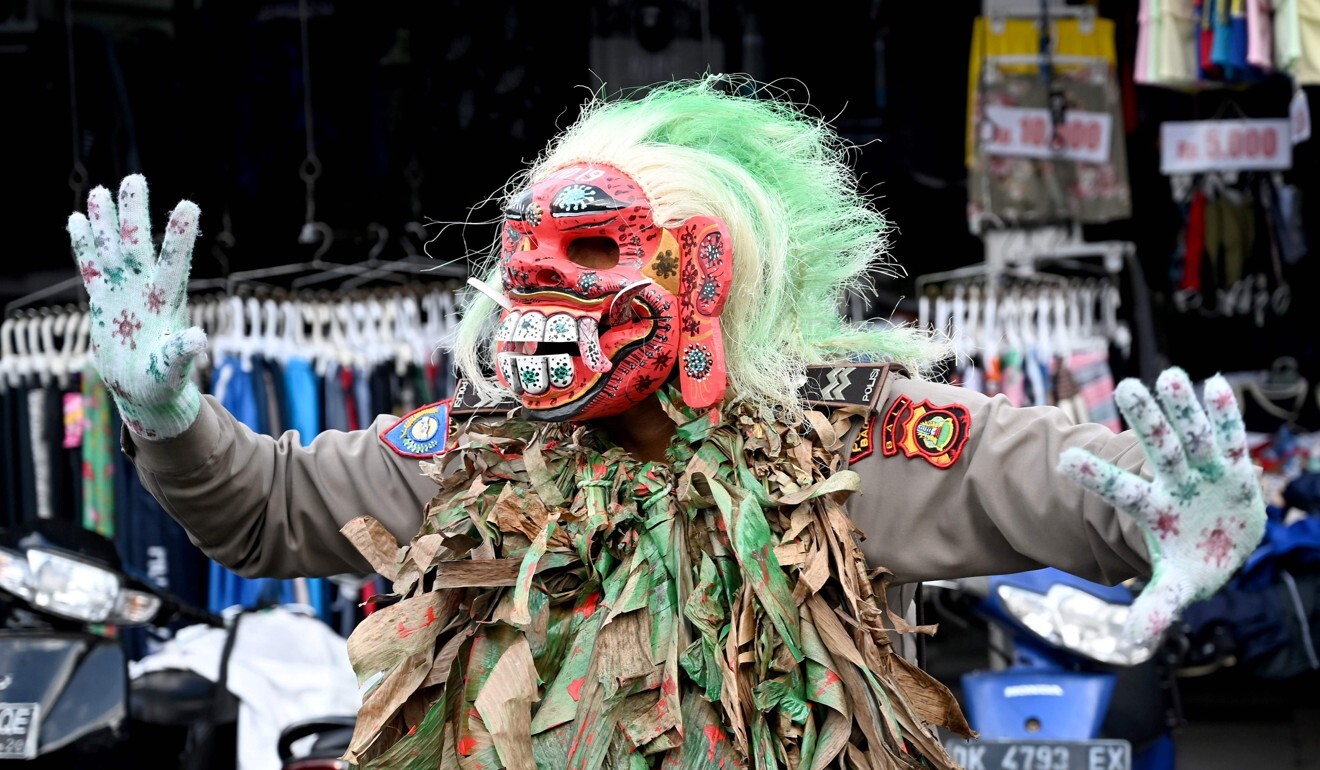 A Bali police officer wears a mask while trying to educate people on Covid-19 at a traditional market in Kerobokan, near Denpasar on Thursday. Photo: AFP