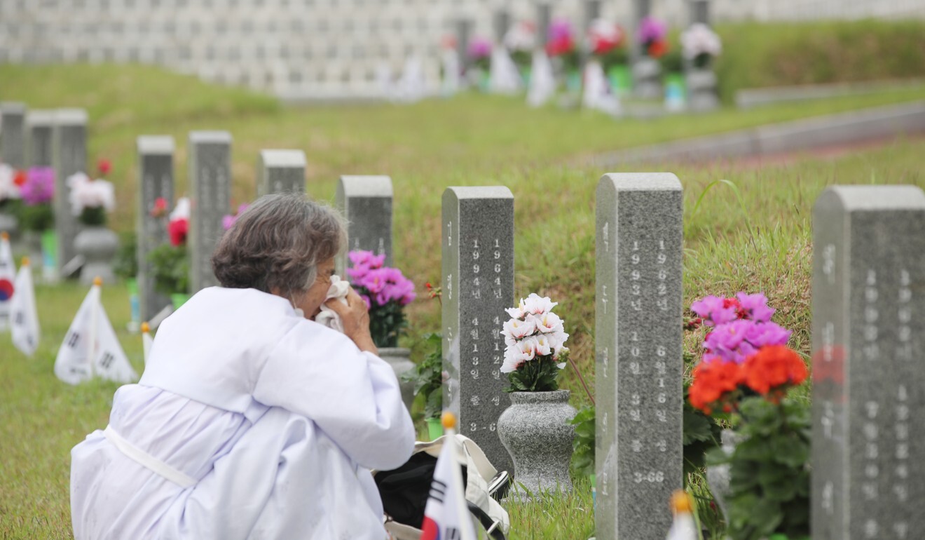 A woman weeps near a grave at cemetery honouring those killed in the 1980 Gwangju democracy uprising. Photo: EPA