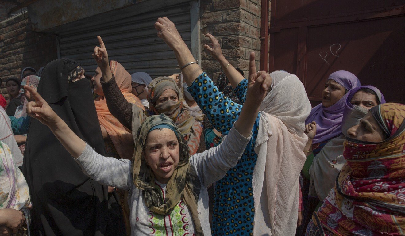 Kashmiri women protest near residential buildings damaged during the shoot-out. Photo: AP