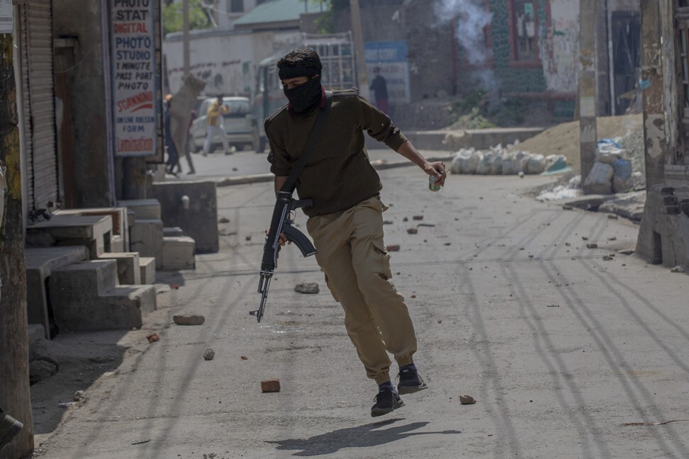 An Indian policeman runs for cover as Kashmiri men throw stones. Photo: AP
