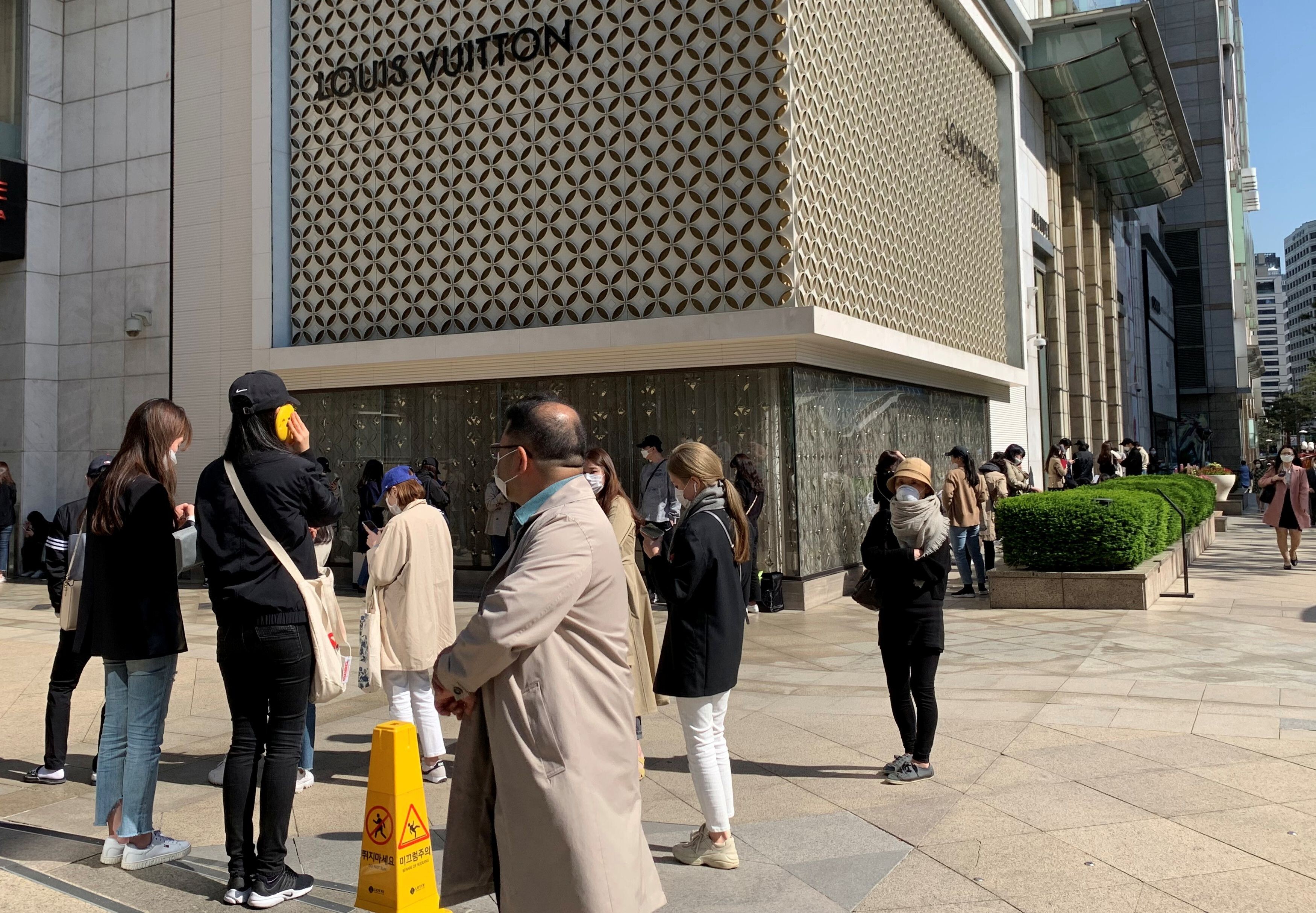 Queue of shoppers outside Louis Vuitton store on Champs Elysees in