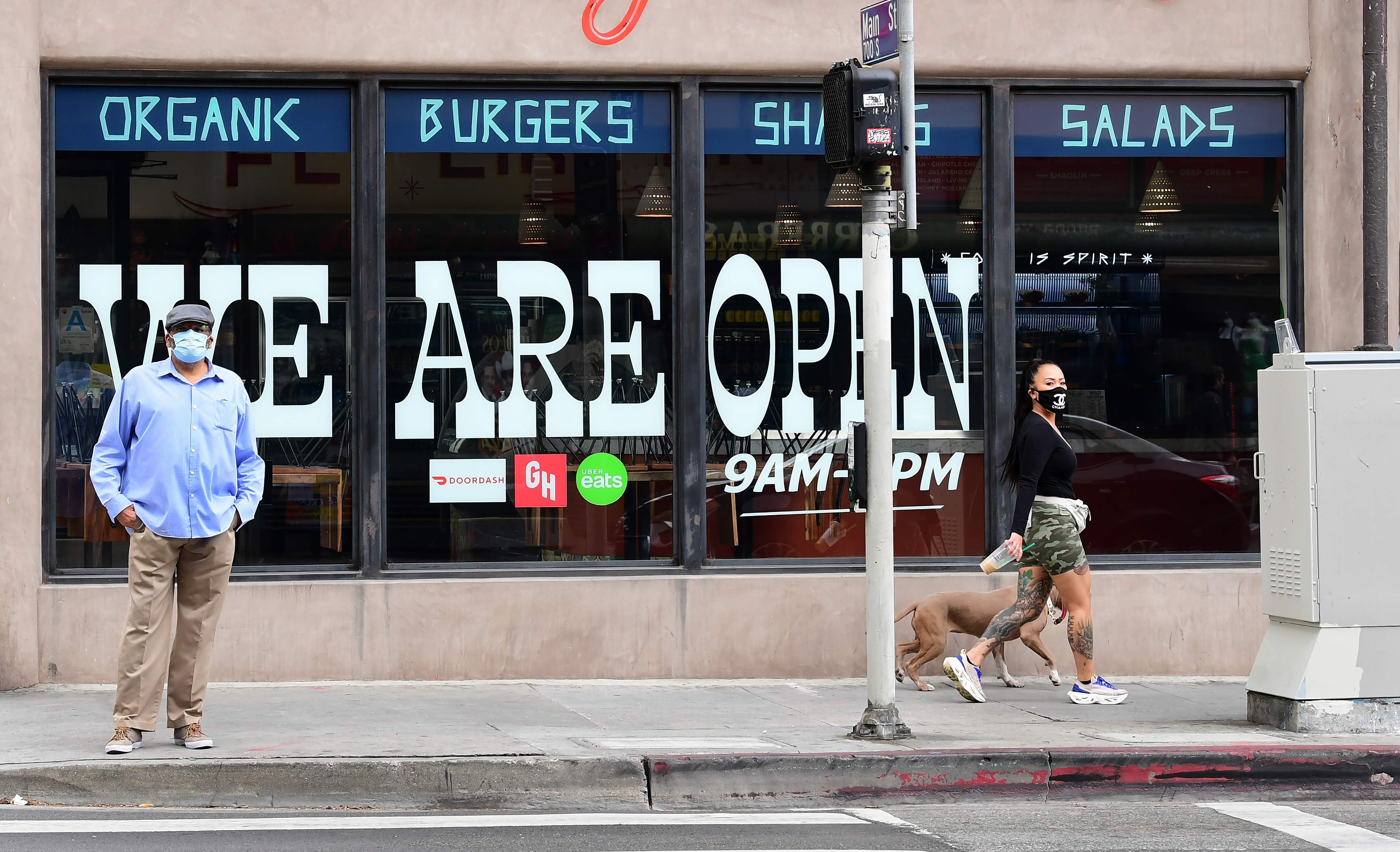 Pedestrians in front of a Los Angeles restaurant that is open for takeout only. California Governor Gavin Newsom announced guidelines for reopening that include self-distancing and stricter cleanliness procedures. Photo: AFP