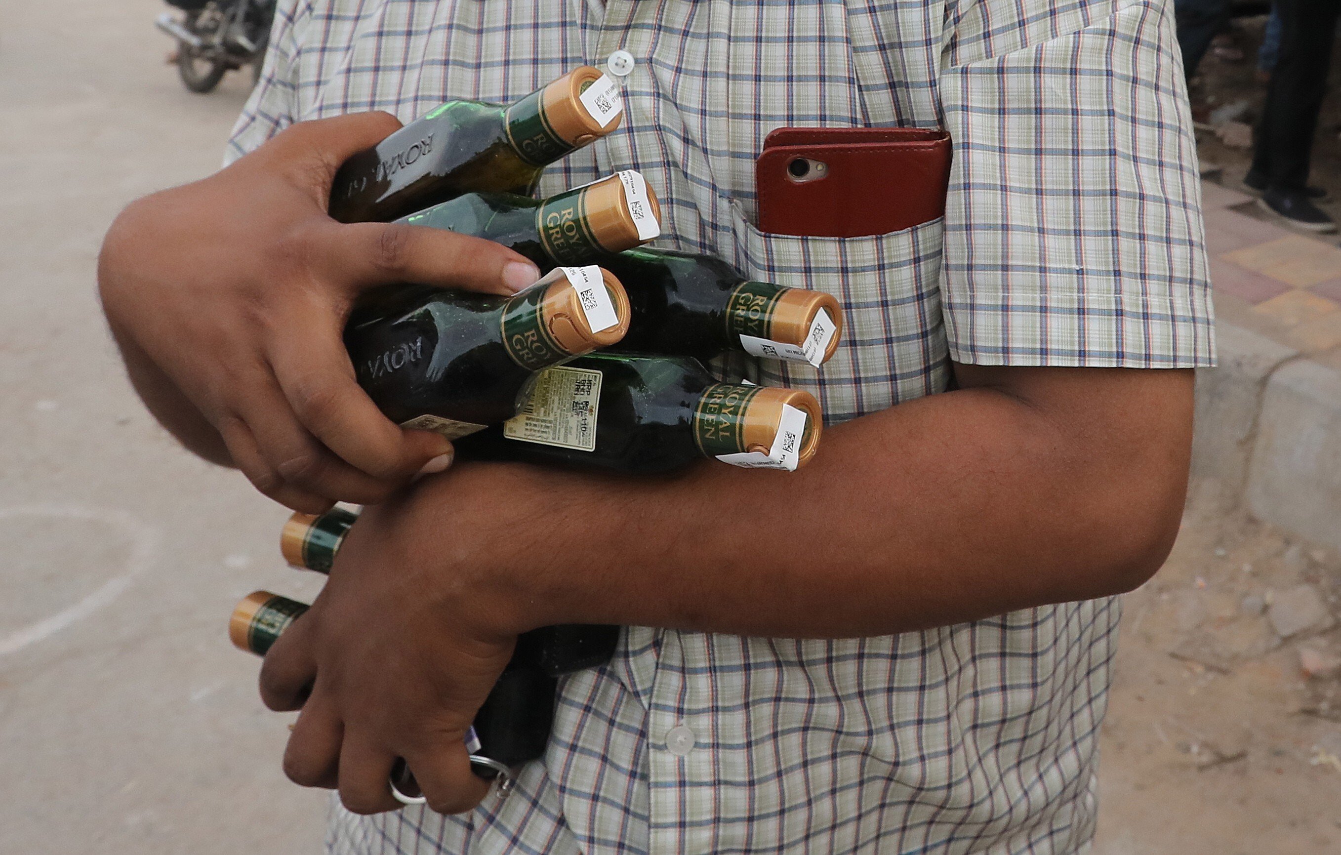 A man buys numerous bottles of liquor after India relaxed restrictions on the sale of alcohol earlier in May, amid concerns about the financial impact of lost revenue. But increased alcohol consumption has led to a rise in domestic abuse, women’s groups say. Photo: EPA-EFE