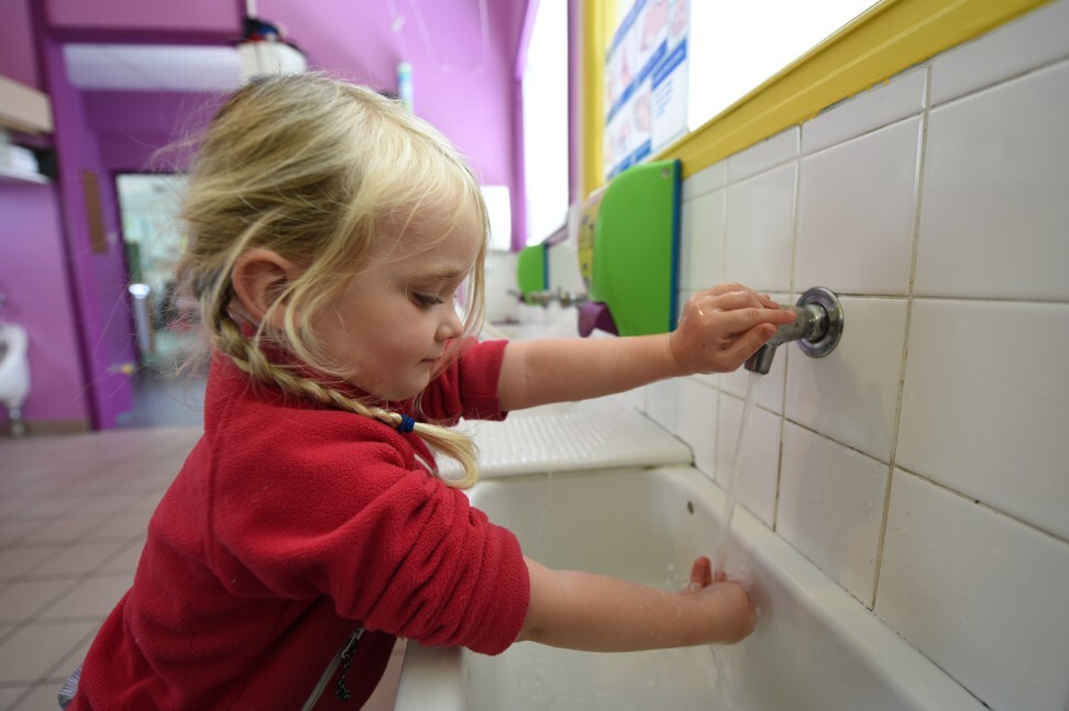A girl washes her hand at school in France. Photo: AFP