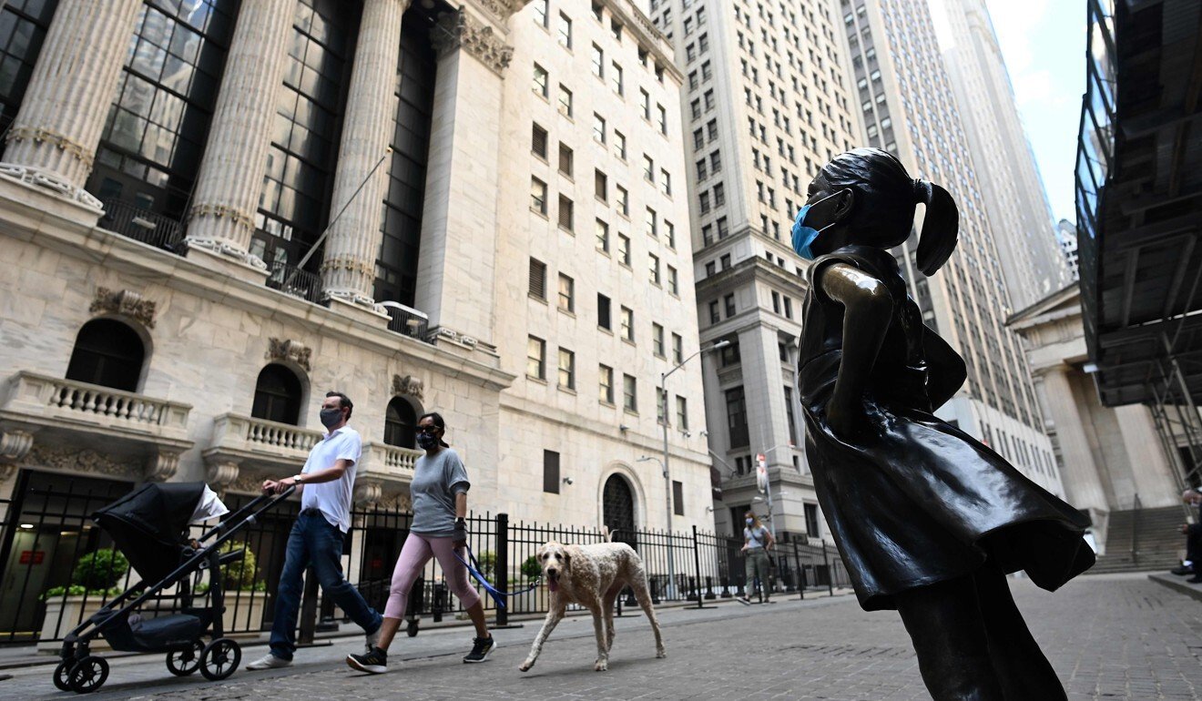 The Fearless Girl statue, now masked, overlooking the New York Stock Exchange. Photo: AFP