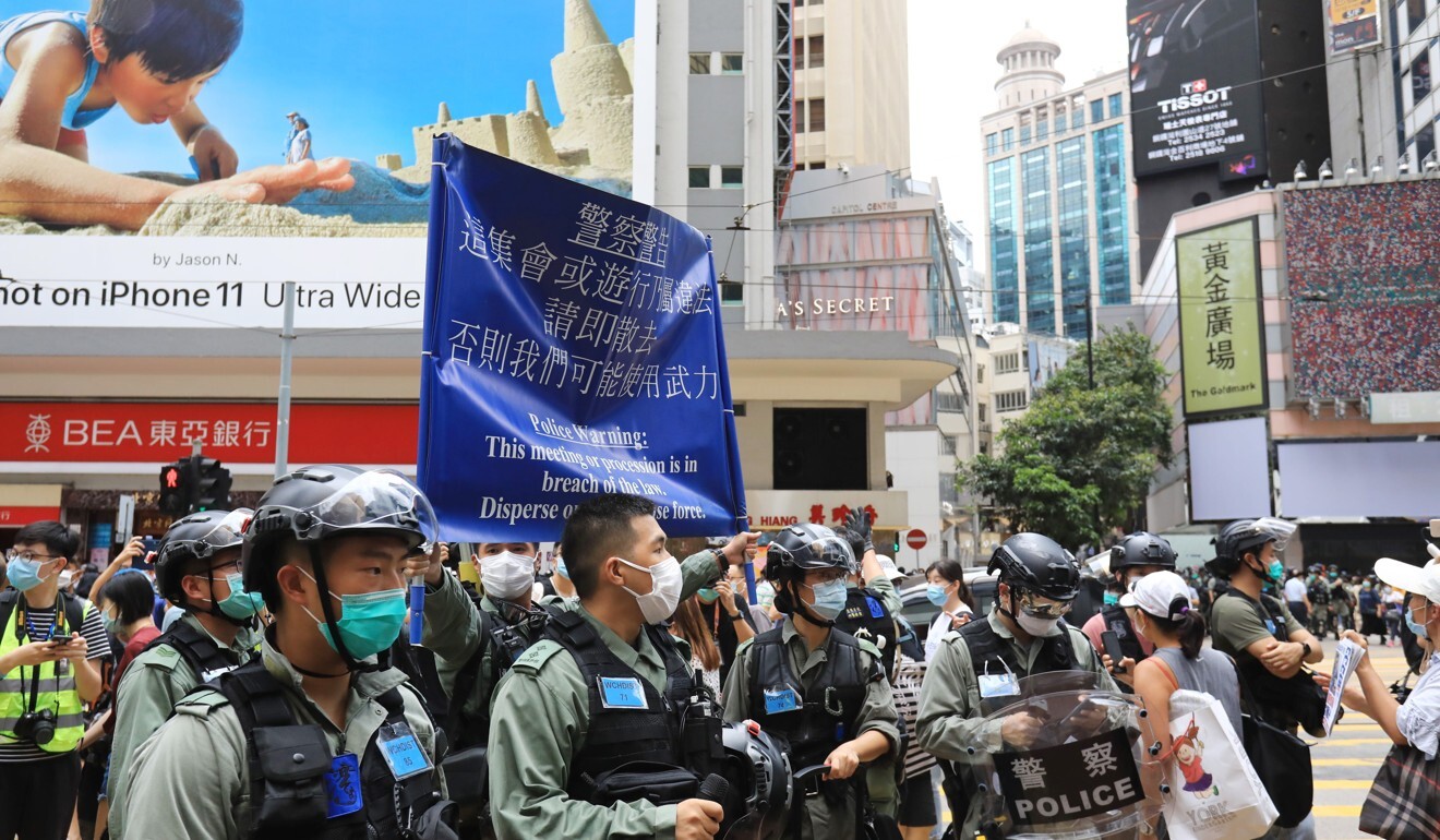 Police hoist a blue flag in Causeway Bay indicating demonstrators should disperse. Photo: May Tse