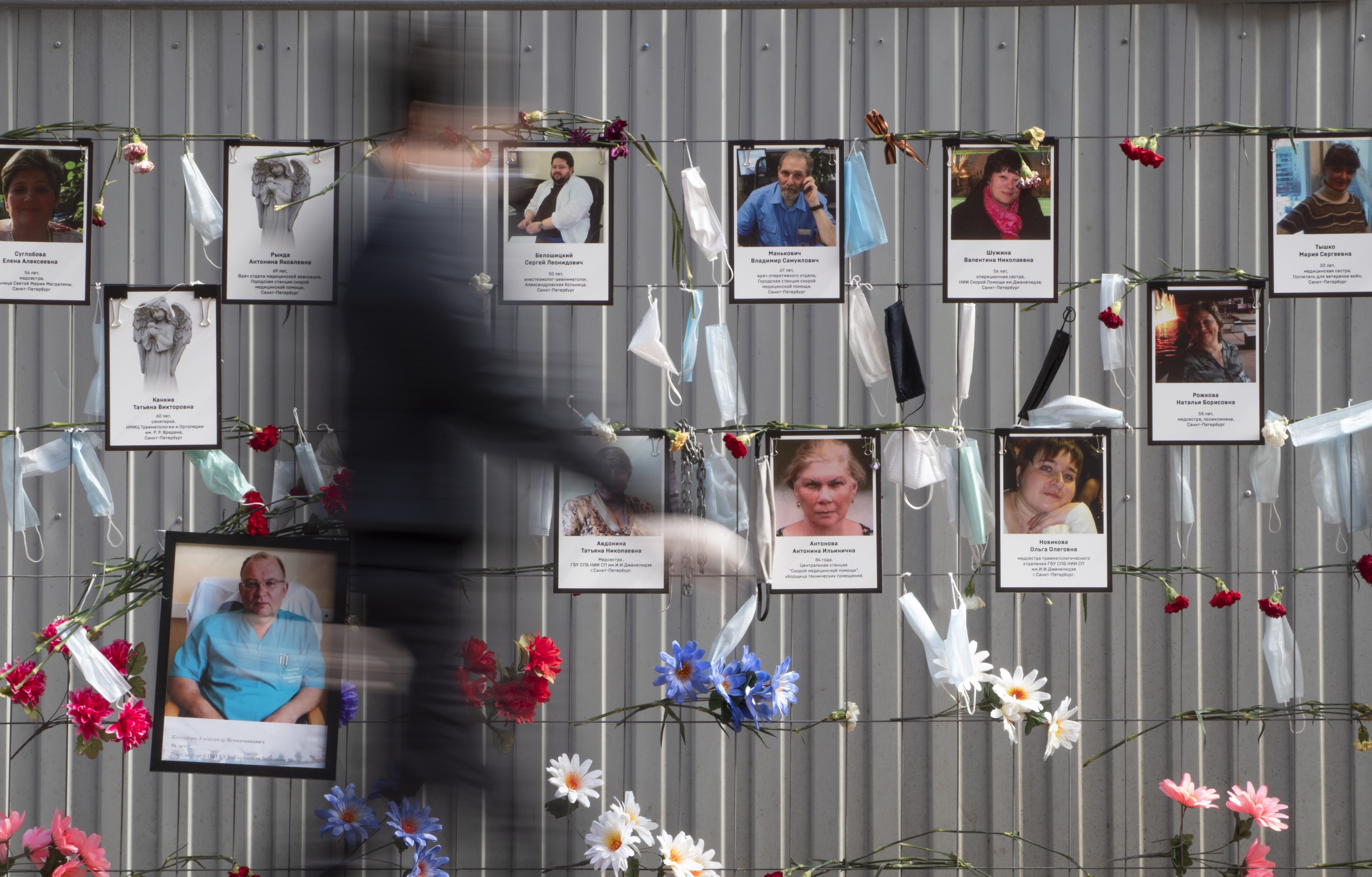 Medical face masks and portraits of medical workers who died from coronavirus infection, hang at a unofficial memorial in St Petersburg, Russia. Photo: AP