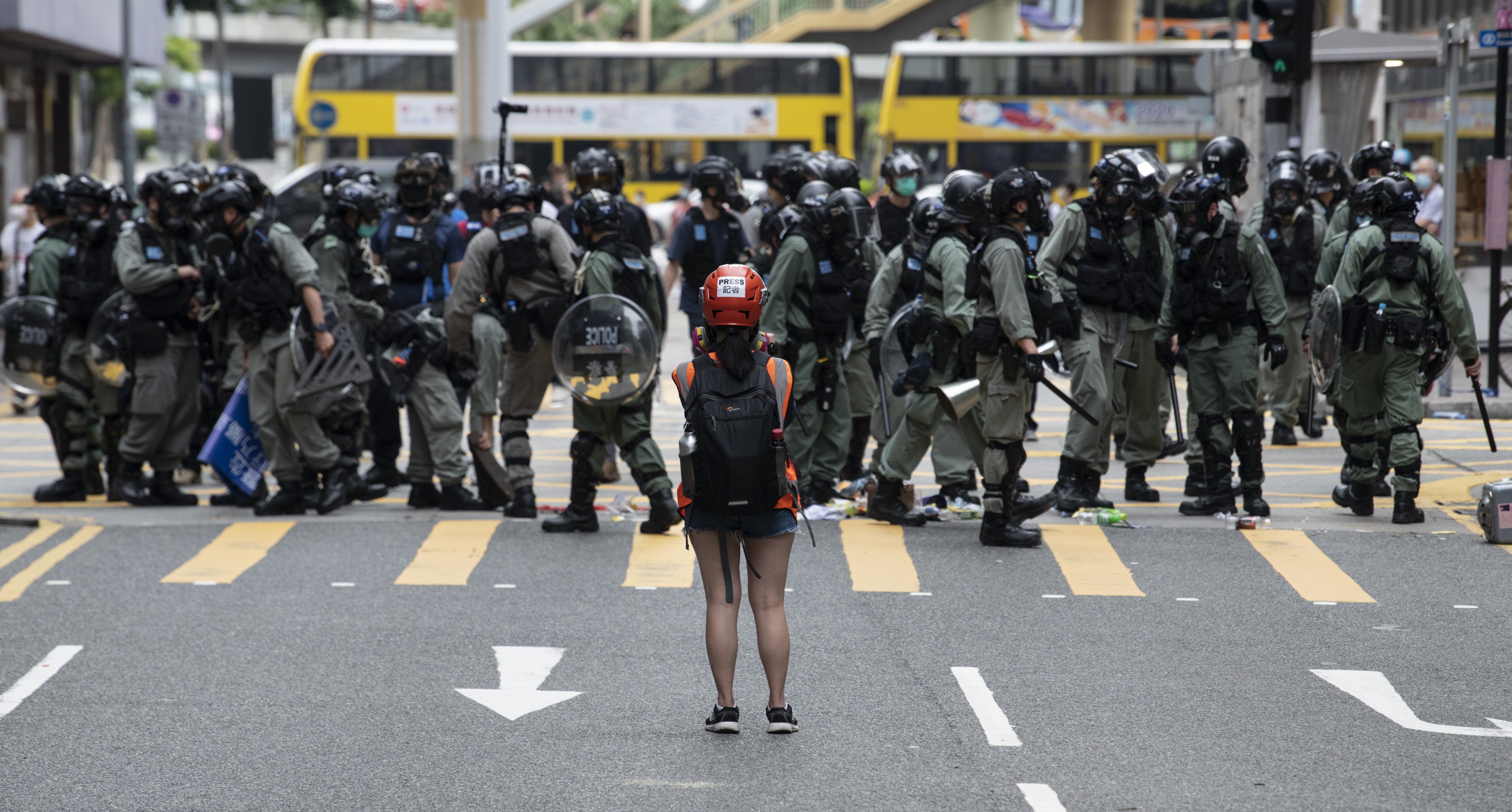 A woman stands in front of police during a protest against Beijing's move to enact a new national security law for Hong Kong, in Causeway Bay on May 24. Photo: DPA