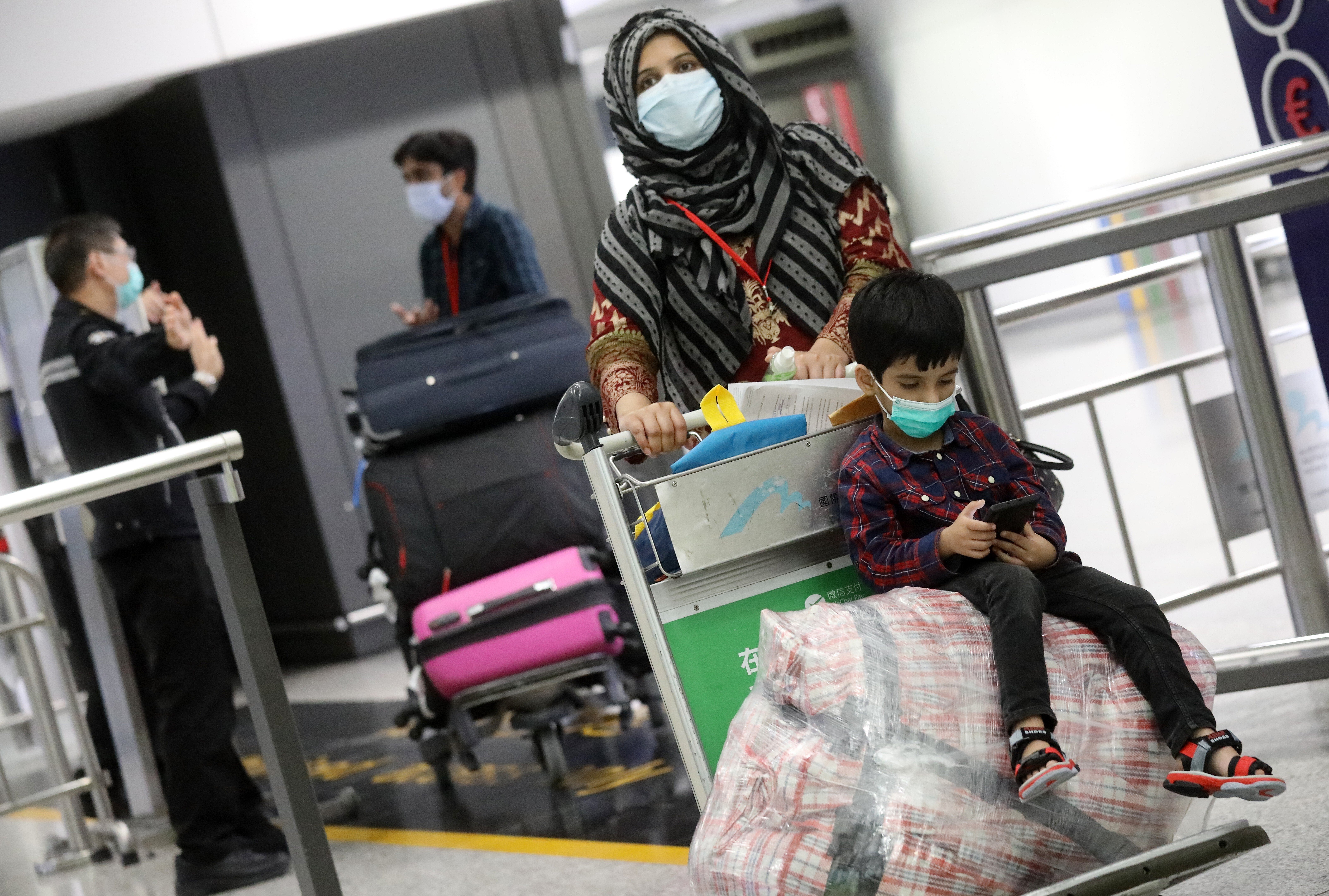 Hong Kong residents returning from Pakistan walk through the airport on April 30. Many were unhappy to be sent to a quarantine centre for 14 days. Photo: K.Y. Cheng