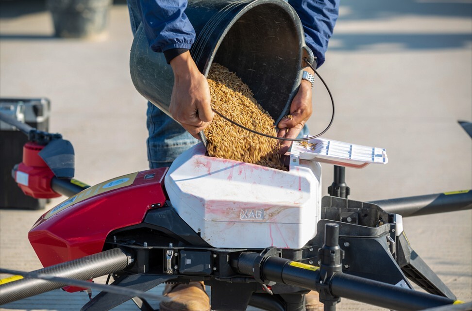 A farmer in the southern city of Guangzhou loads rice seeds into the JetSeed granule system attached to an XAG drone. Photo: Handout