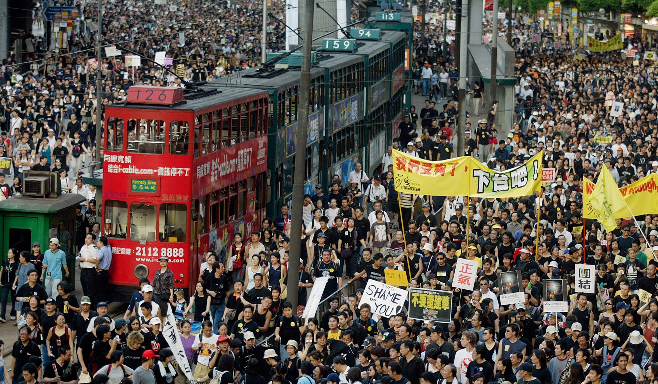 Trams sit stranded as thousands of people block the streets during a protest against Article 23 legislation in Hong Kong on July 1, 2003. Photo: AFP