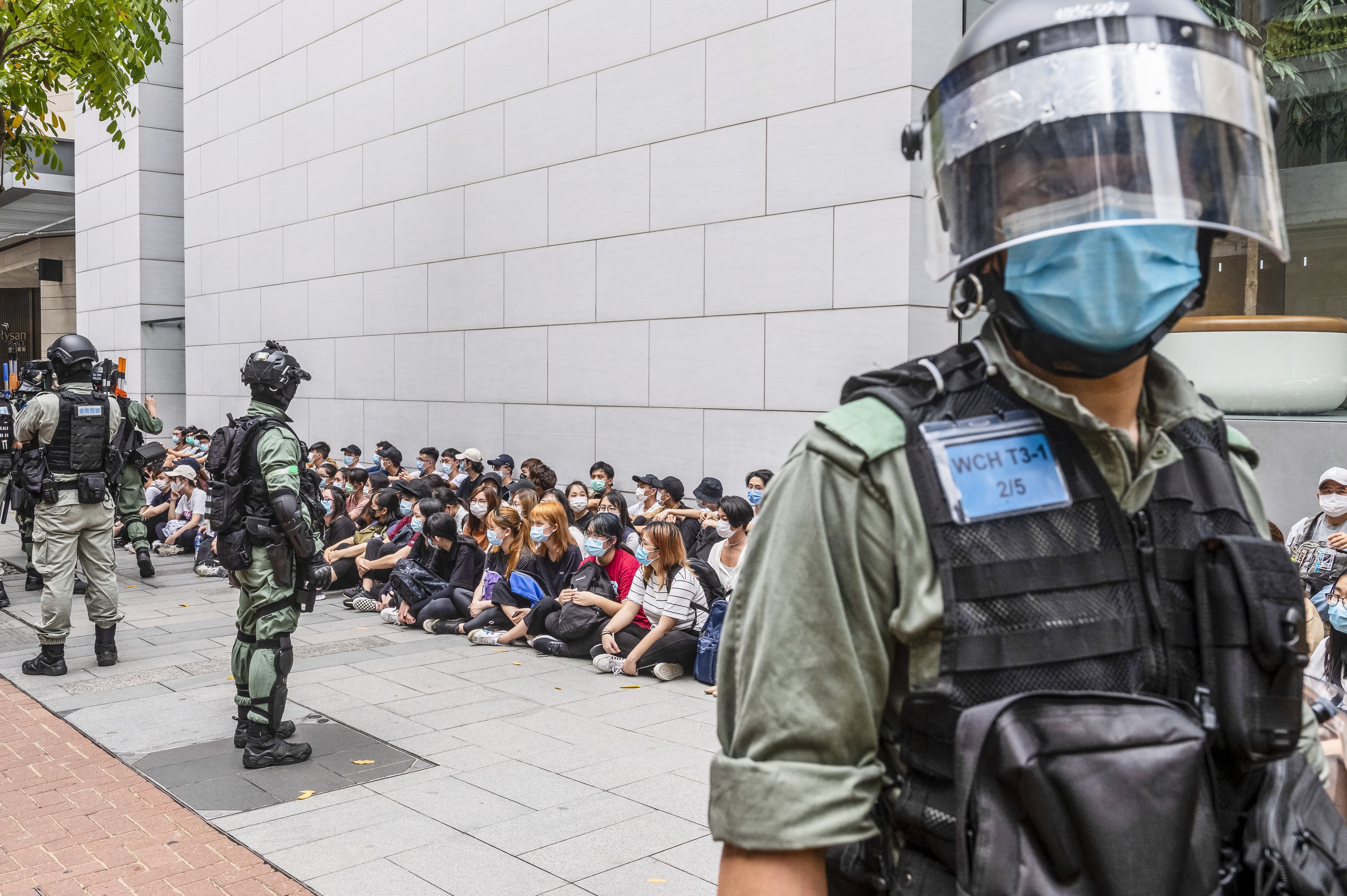 A large group of detainees sit on the ground as the police set up a cordon in Causeway Bay, Hong Kong, on May 27, when hundreds took to the streets to oppose the national anthem law and the national security law. Photo: EPA-EFE