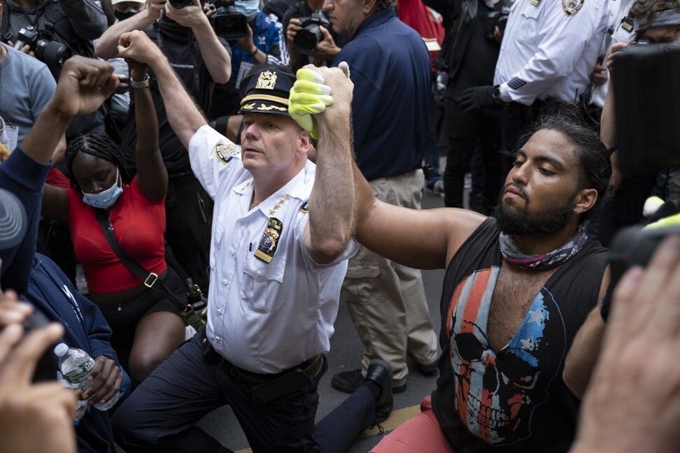 Terence Monahan, New York City’s chief of police, takes a knee with activists. Photo: AP