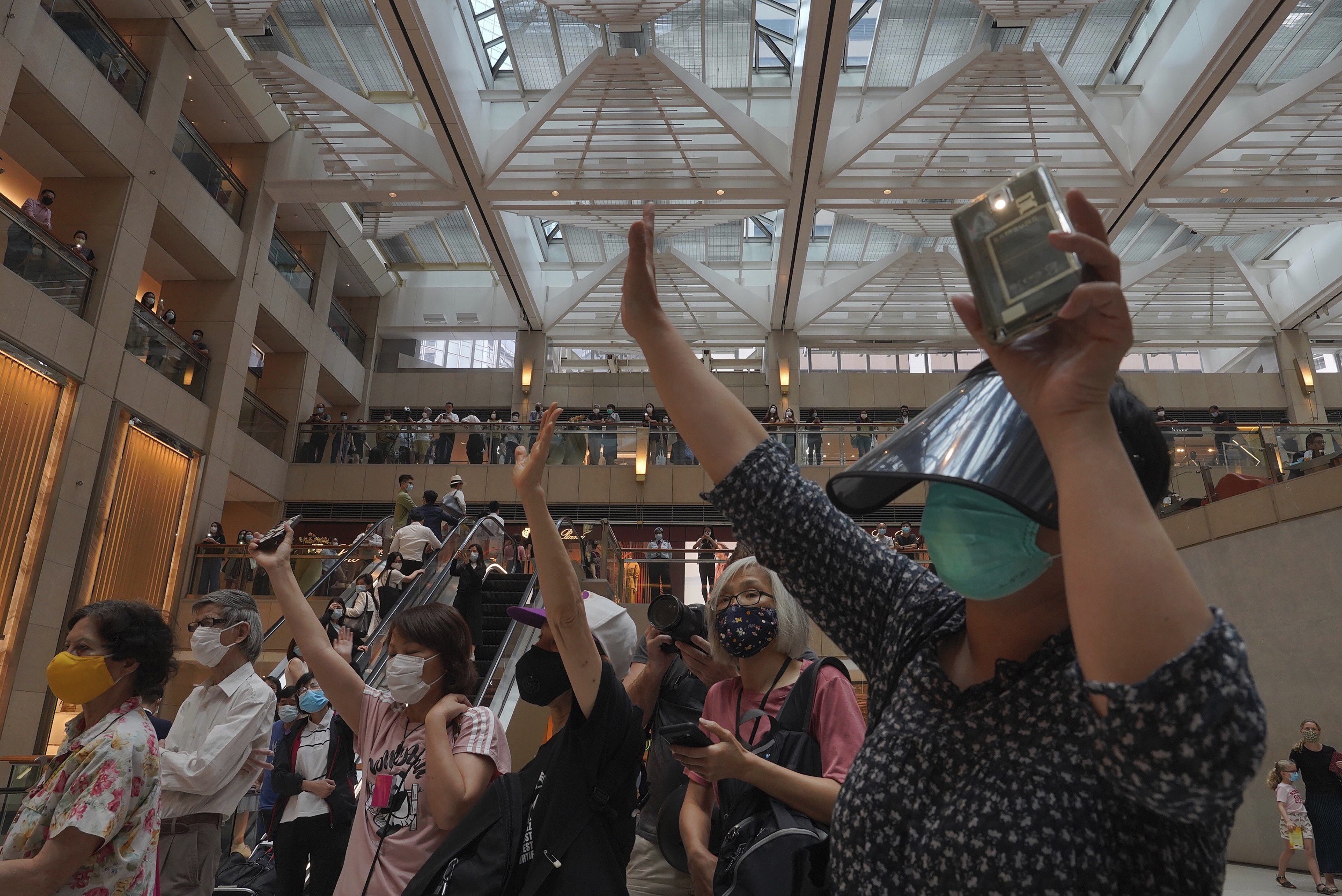 Protesters gesture with five fingers, signifying “five demands, not one less”, in a shopping centre during a protest on June 1 against China's national security legislation for Hong Kong. Photo: AP