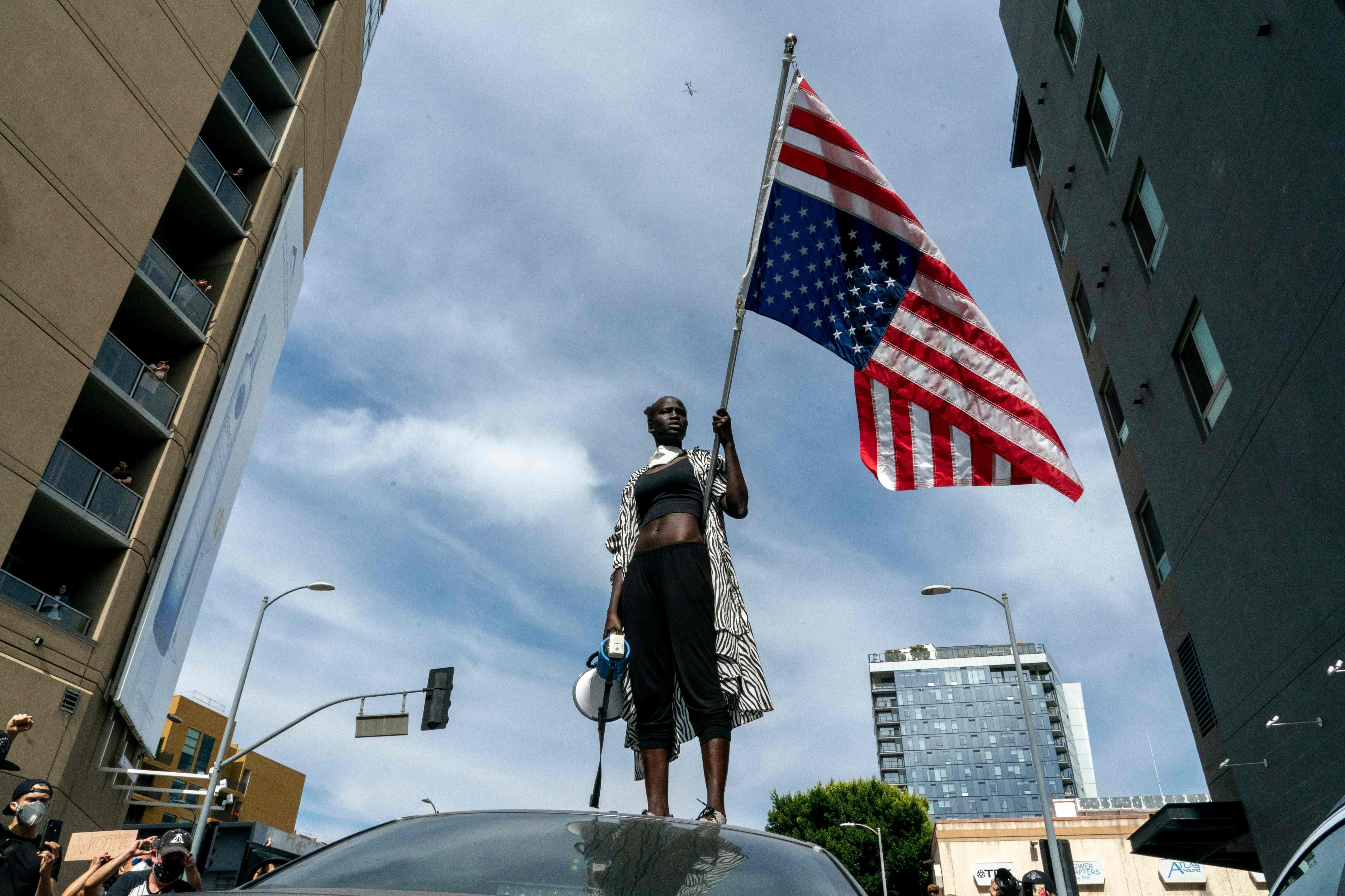 A protester in Los Angeles holds an American flag upside-down, which is considered a symbol of distress. Photo: AFP