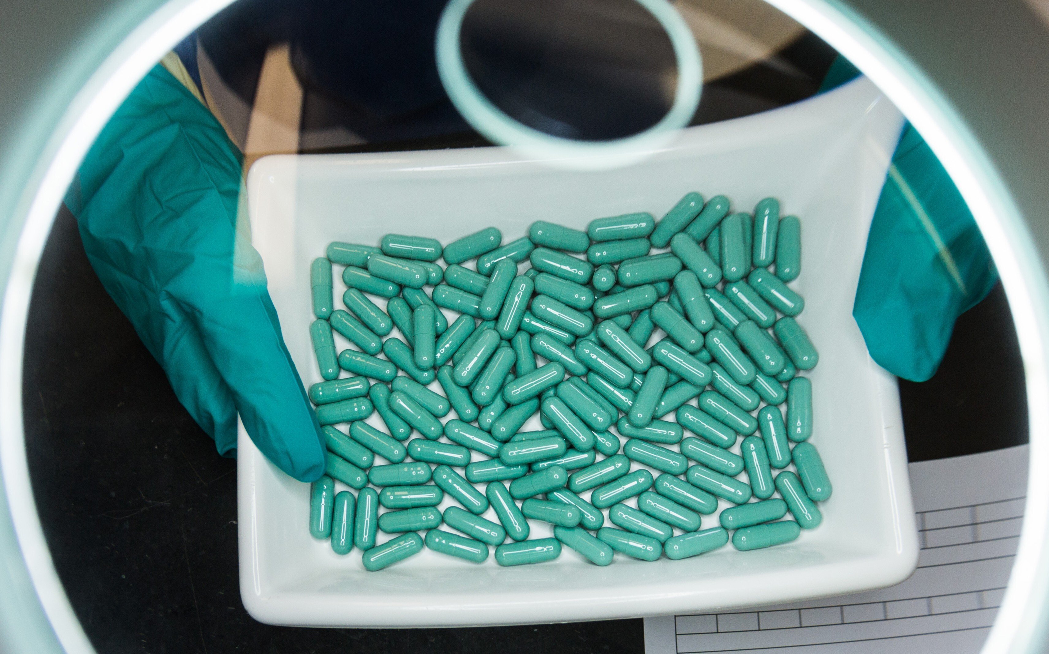 An employee checks the production of capsules at a Stada Arzneimittel durg manufacturing facility in Germany. Photo: dpa